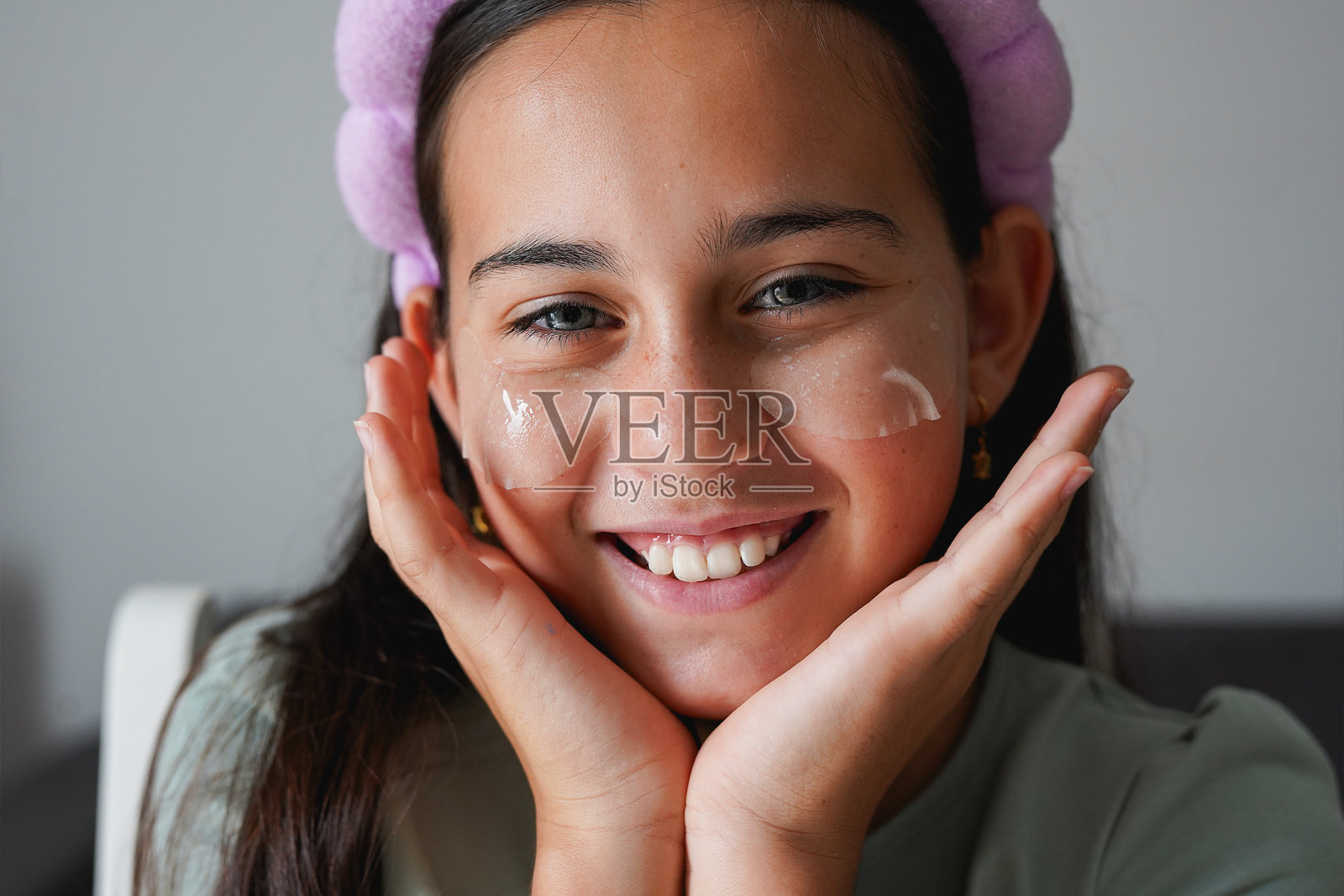 快乐的小女孩使用美容眼贴护肤 - 护理、社交媒体潮流和童年概念照片摄影图片