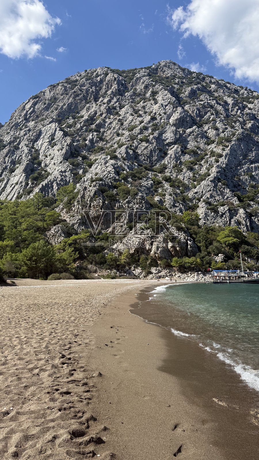 碧绿的海水与山峰在晴朗的天空下照片摄影图片