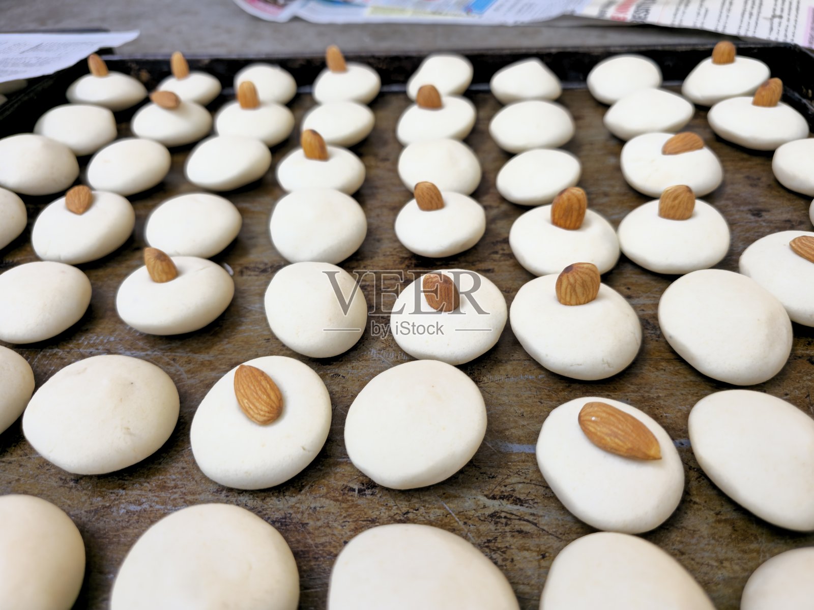 烤箱烤盘上摆放着新鲜出炉的、饰有杏仁的印度酥饼照片摄影图片