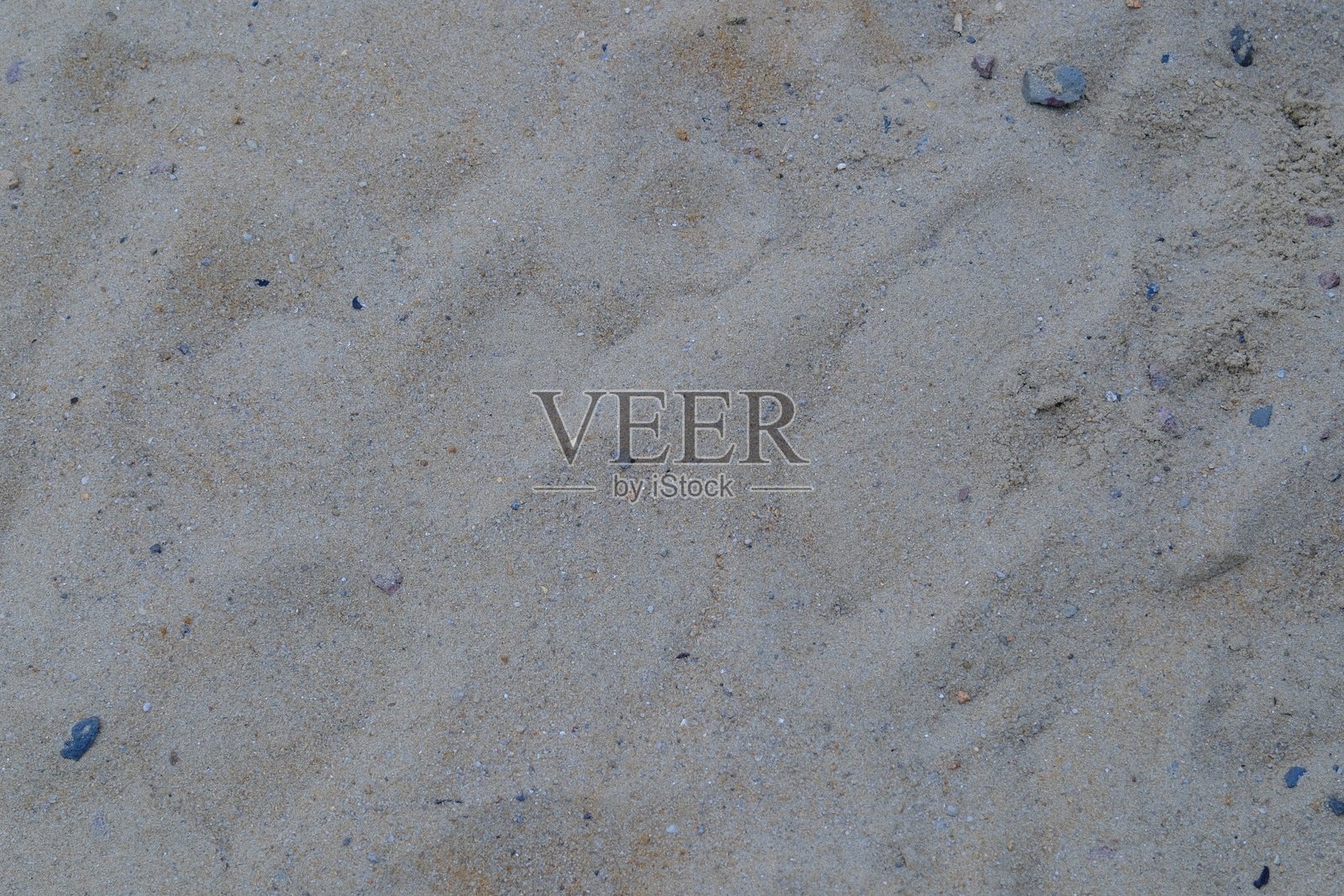 地面近景展示了沙滩的质感和散落的鹅卵石照片摄影图片