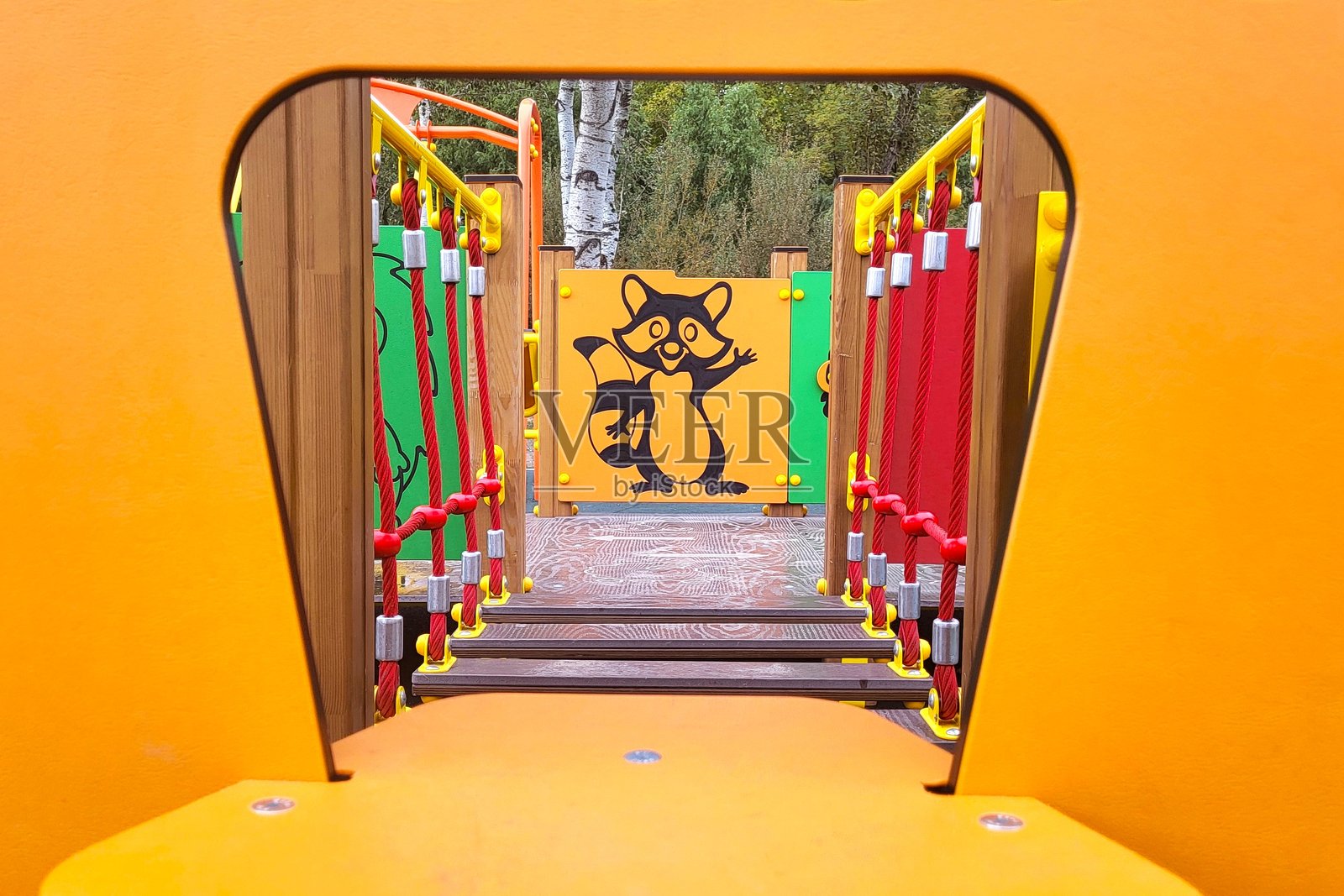 透过橙色框架看到的现代木制游乐场桥梁照片摄影图片