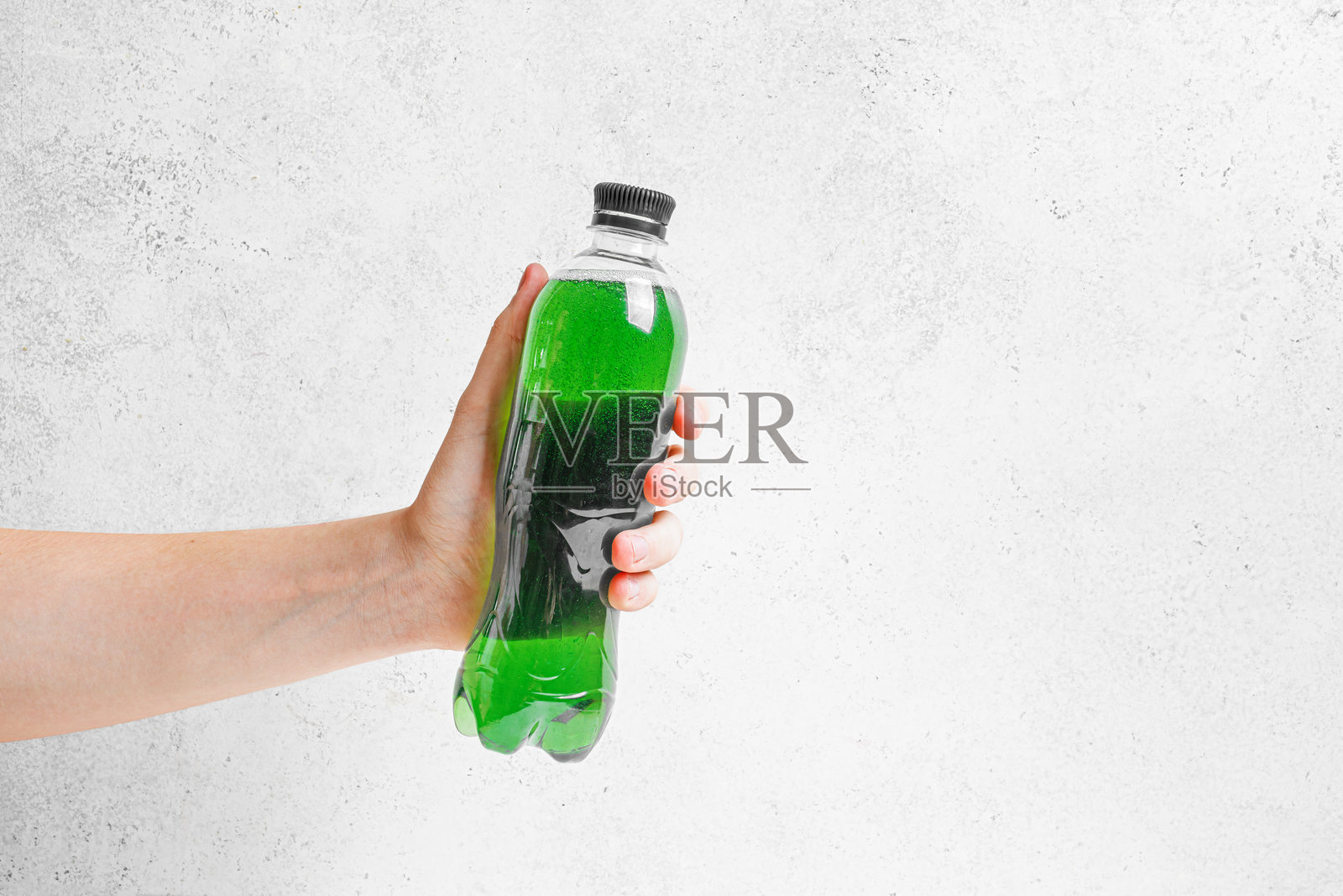 手持一瓶绿色的叶绿素水照片摄影图片