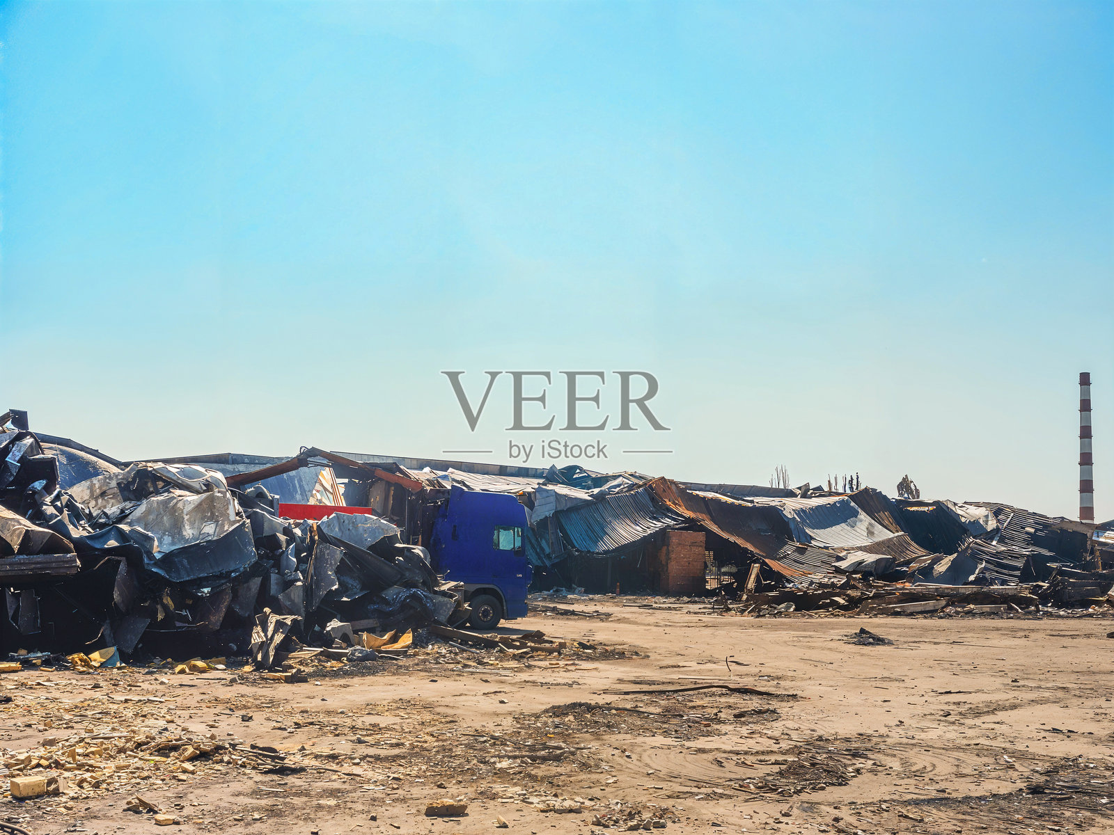 晴空下的卡车和瓦砾,被拆毁的建筑物场景。照片摄影图片