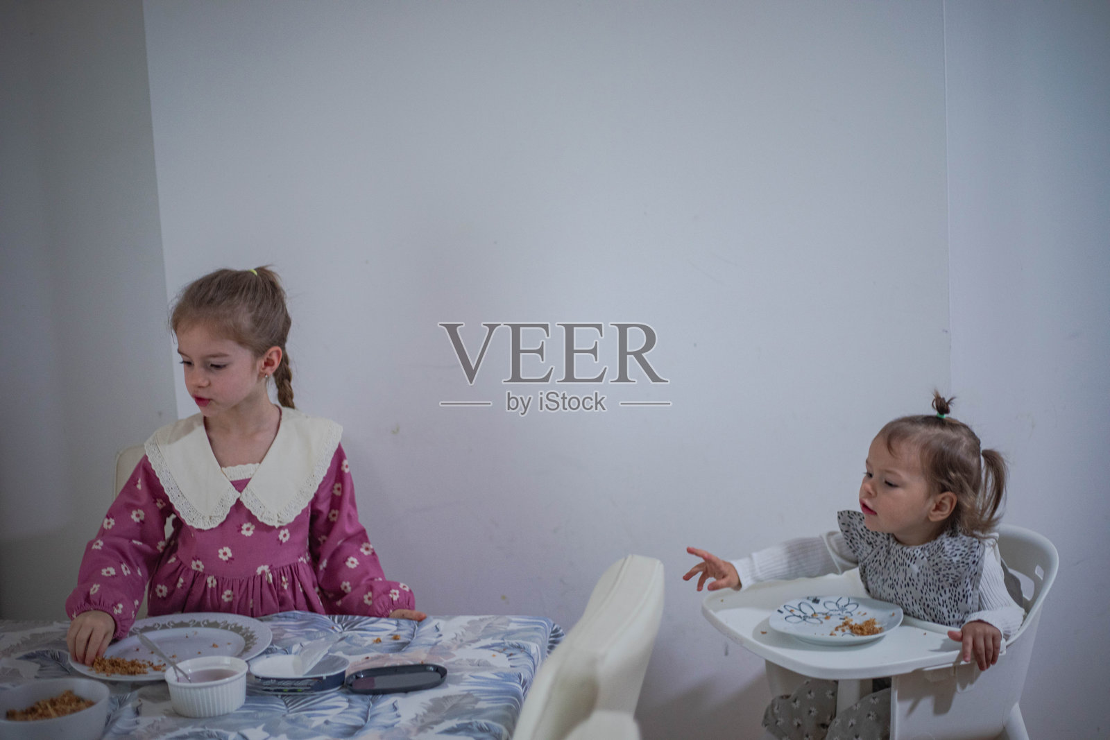 小女孩们在厨房的餐桌旁用餐照片摄影图片