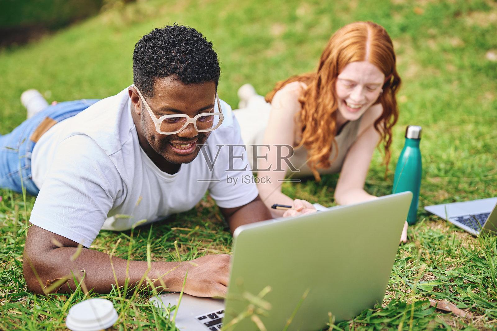 微笑的学生们在户外一起用笔记本电脑学习照片摄影图片
