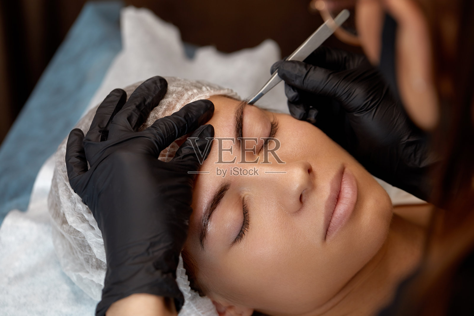 白天在现代美容院接受眉形修饰的女性照片摄影图片