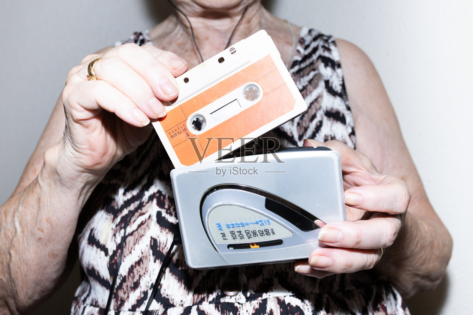 一位年长女性将录音带装入便携式播放器。用户生成内容照片摄影图片