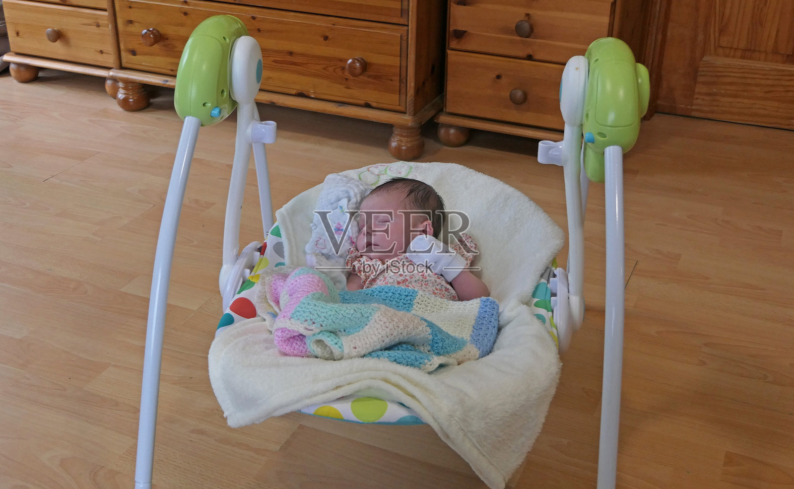 新生儿在摇椅秋千座椅中安睡照片摄影图片