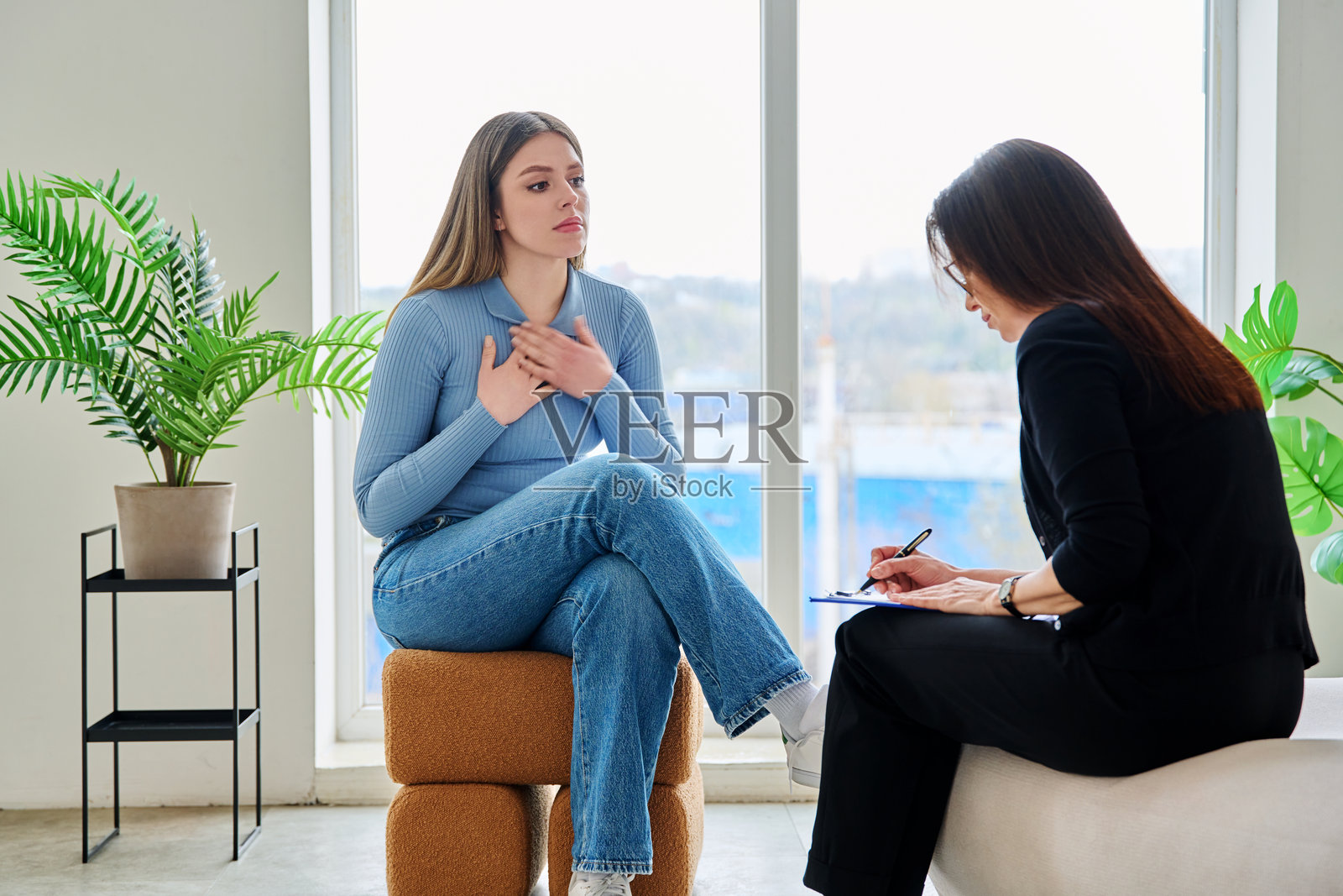 年轻女子在心理治疗师的陪伴下进行心理治疗照片摄影图片