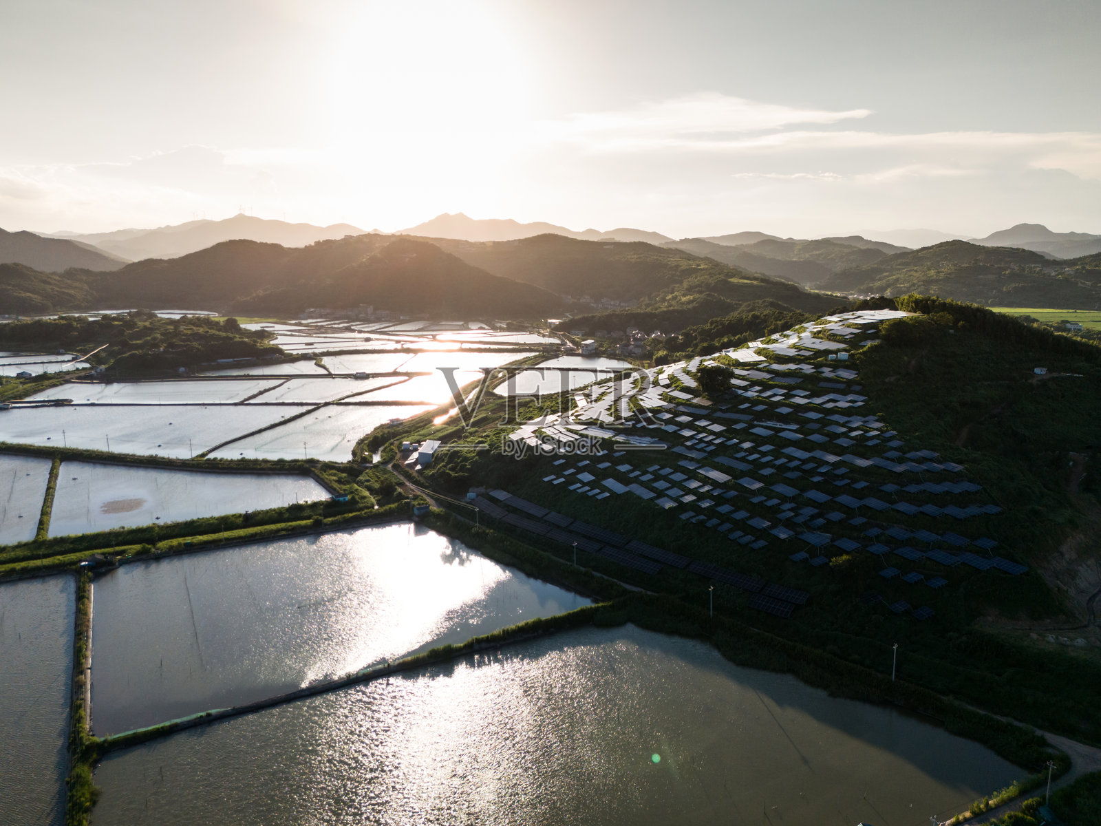日落时分山顶太阳能发电站的鸟瞰图照片摄影图片
