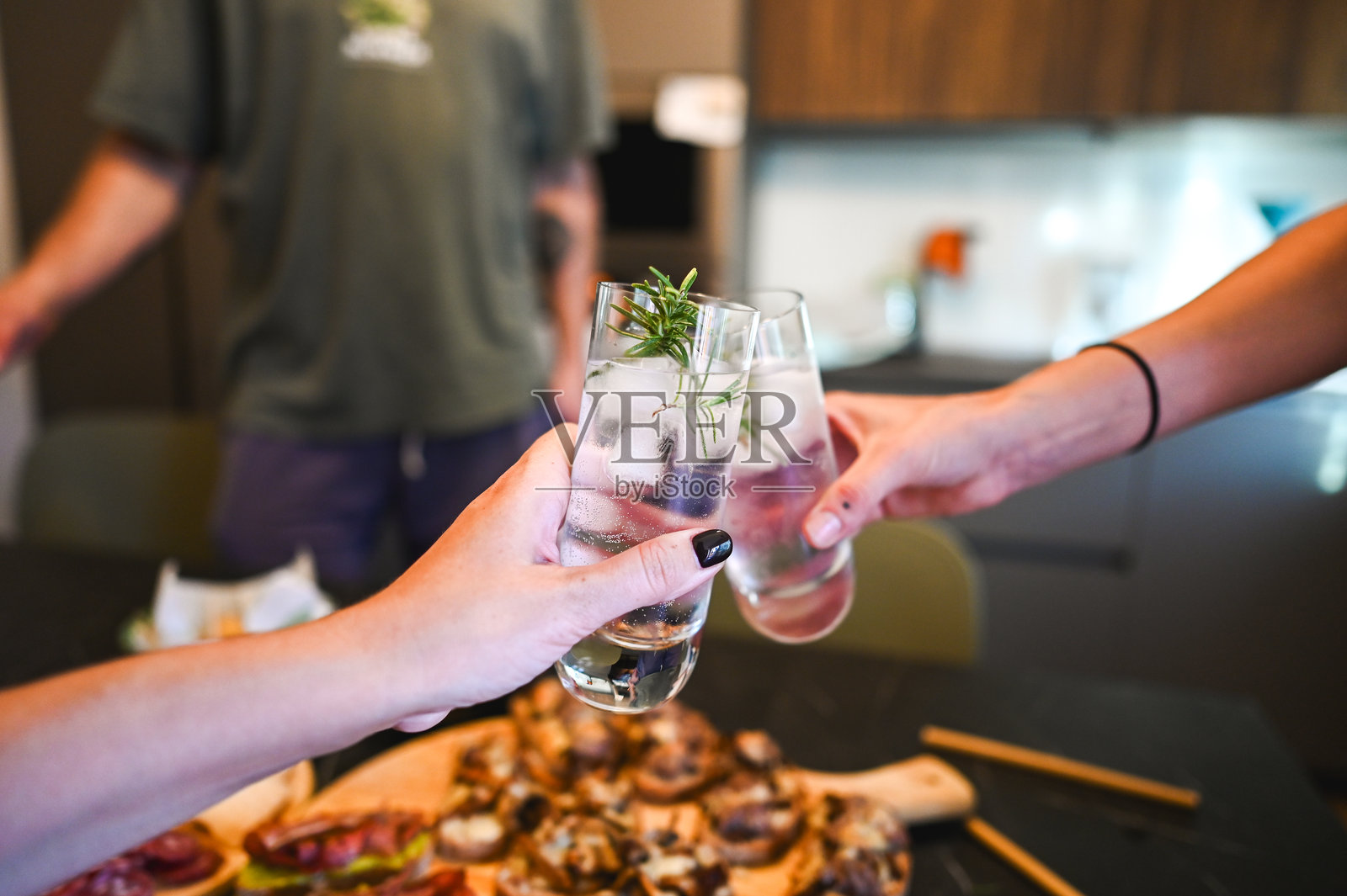 朋友们在派对上举杯畅饮,享用开胃小吃照片摄影图片