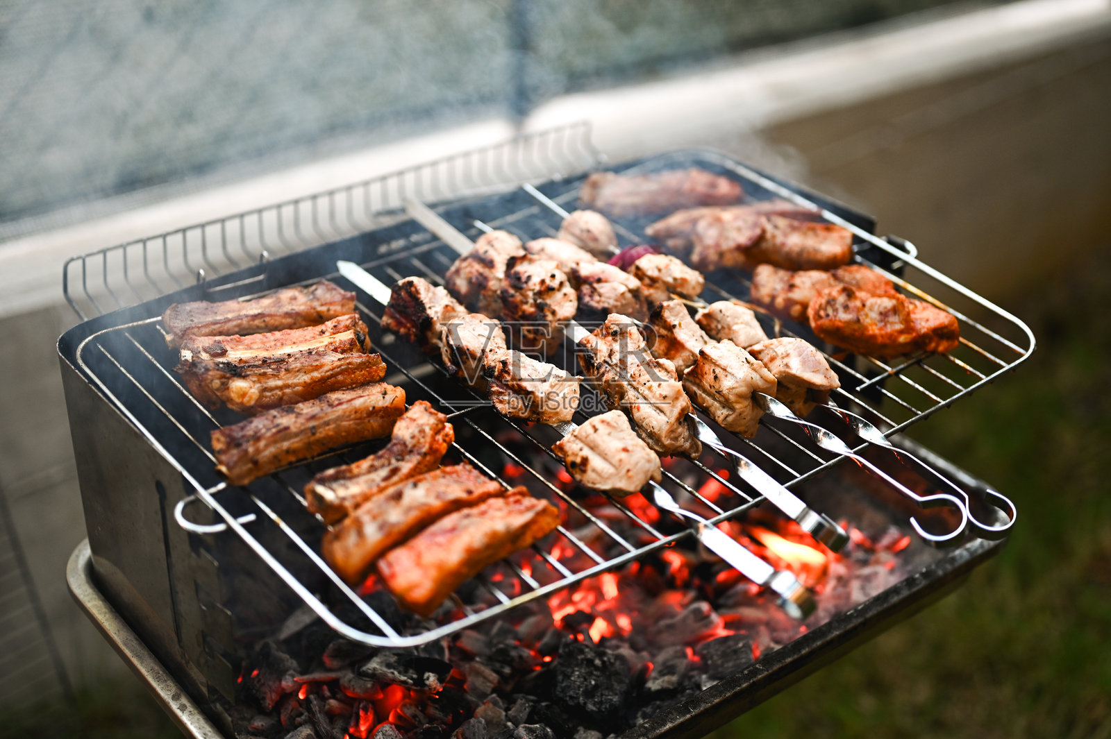 在炭火烧烤架上烤肉串和猪肋排照片摄影图片
