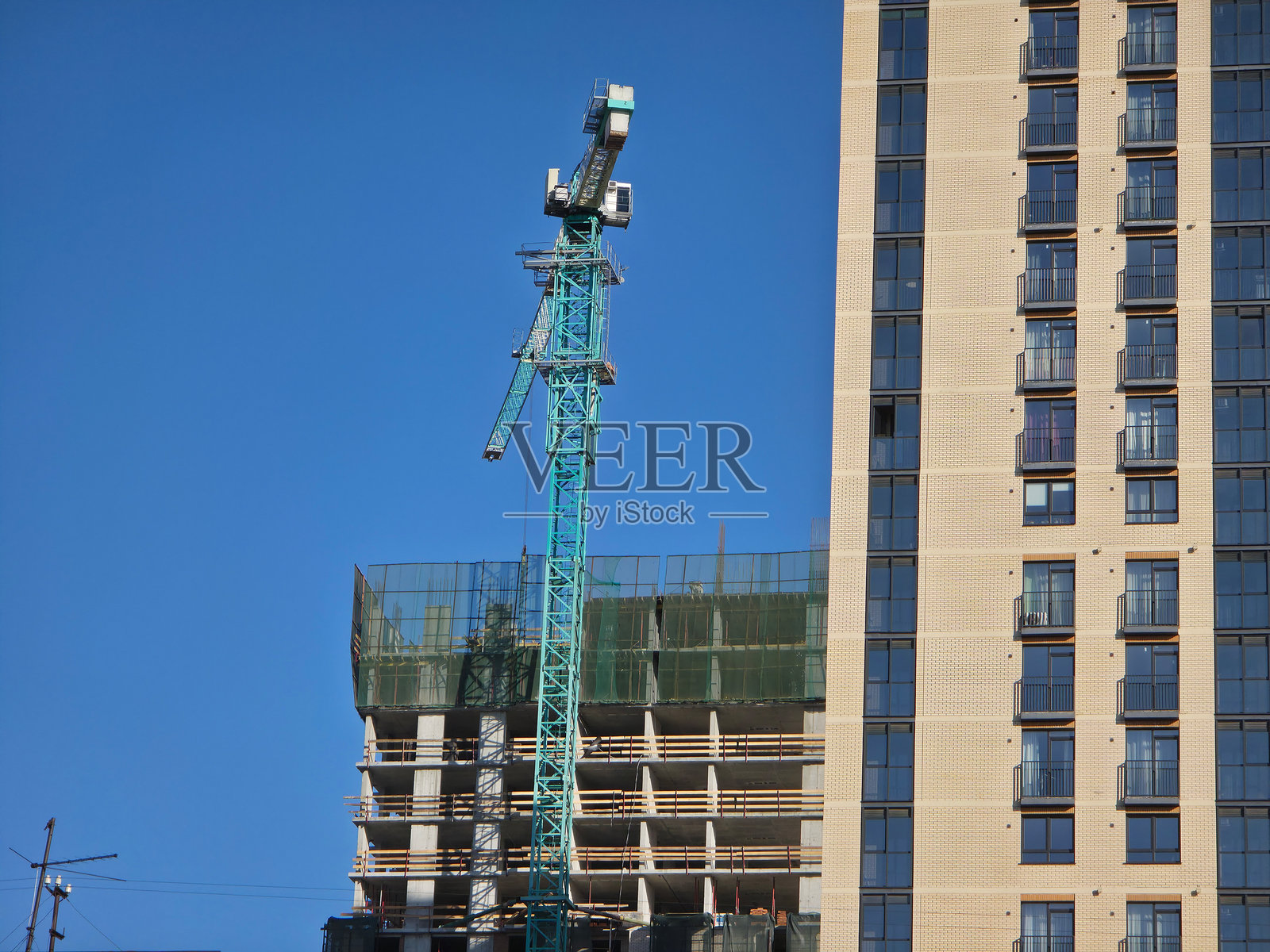 晴朗的蓝天下,塔式起重机和新建的建筑照片摄影图片