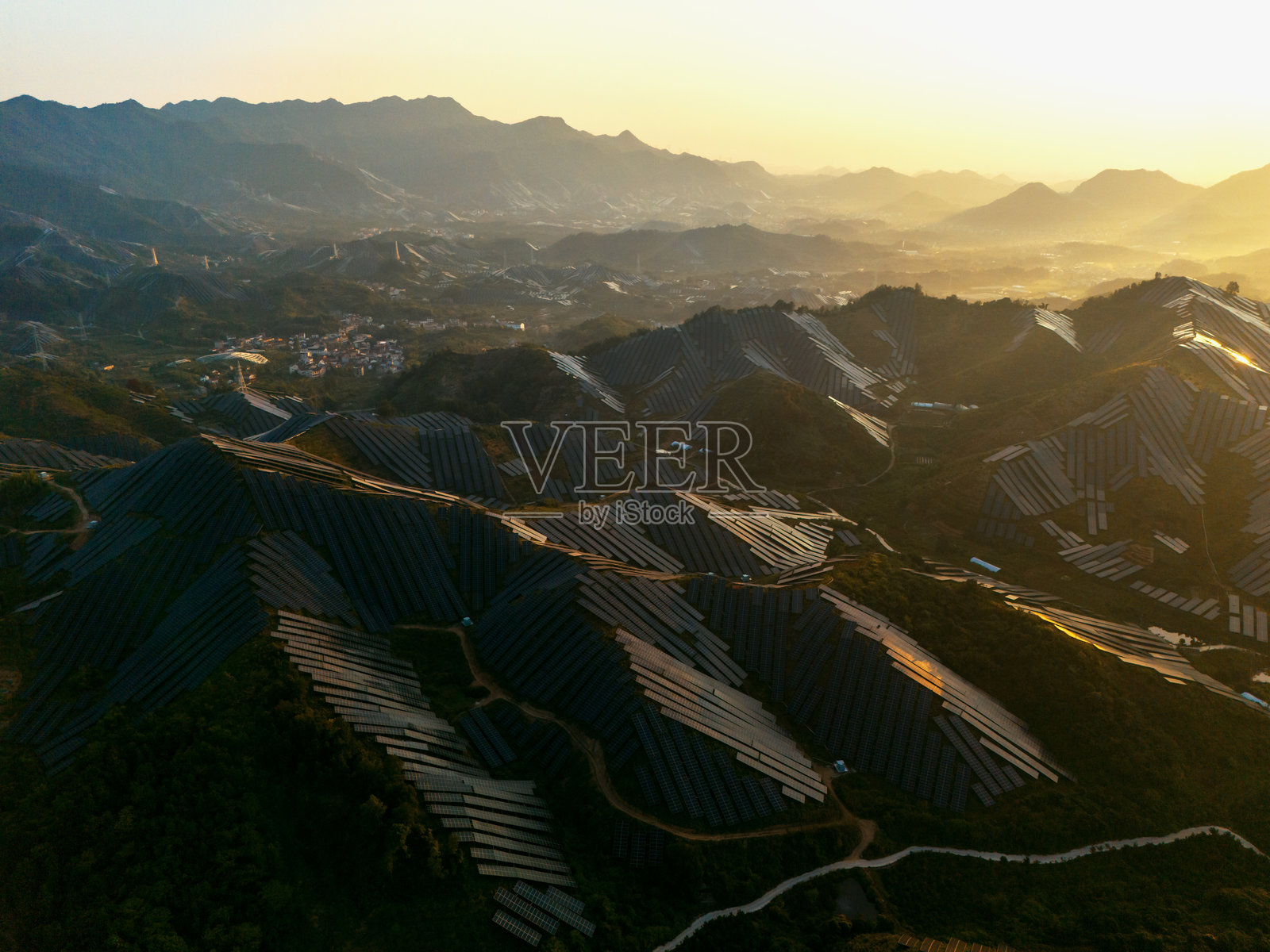 日落时分山坡上的太阳能电池板照片摄影图片