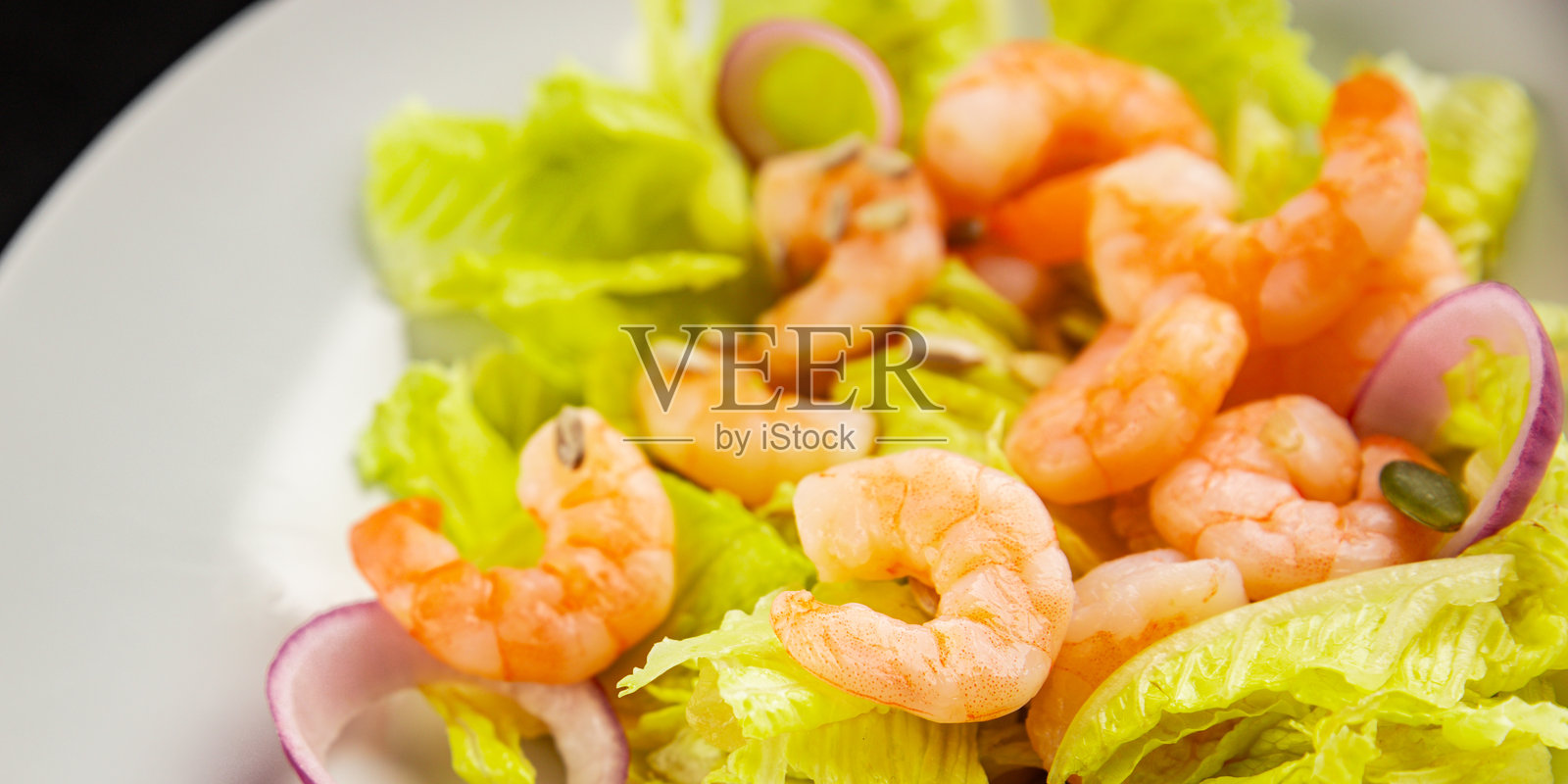 美味的鲜虾沙拉,作为小吃,背景是餐桌上的新鲜美食,俯视角度,有复制空间,适合生酮饮食、旧石器饮食、素食和鱼素饮食。照片摄影图片