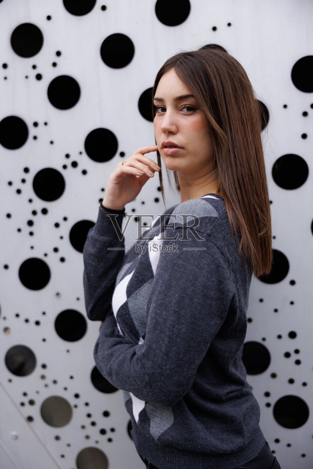 年轻女子独自漫步在巴塞罗那的街道上,面带微笑看向镜头,体现都市生活方式,适合广告宣传的商业图库摄影概念。照片摄影图片