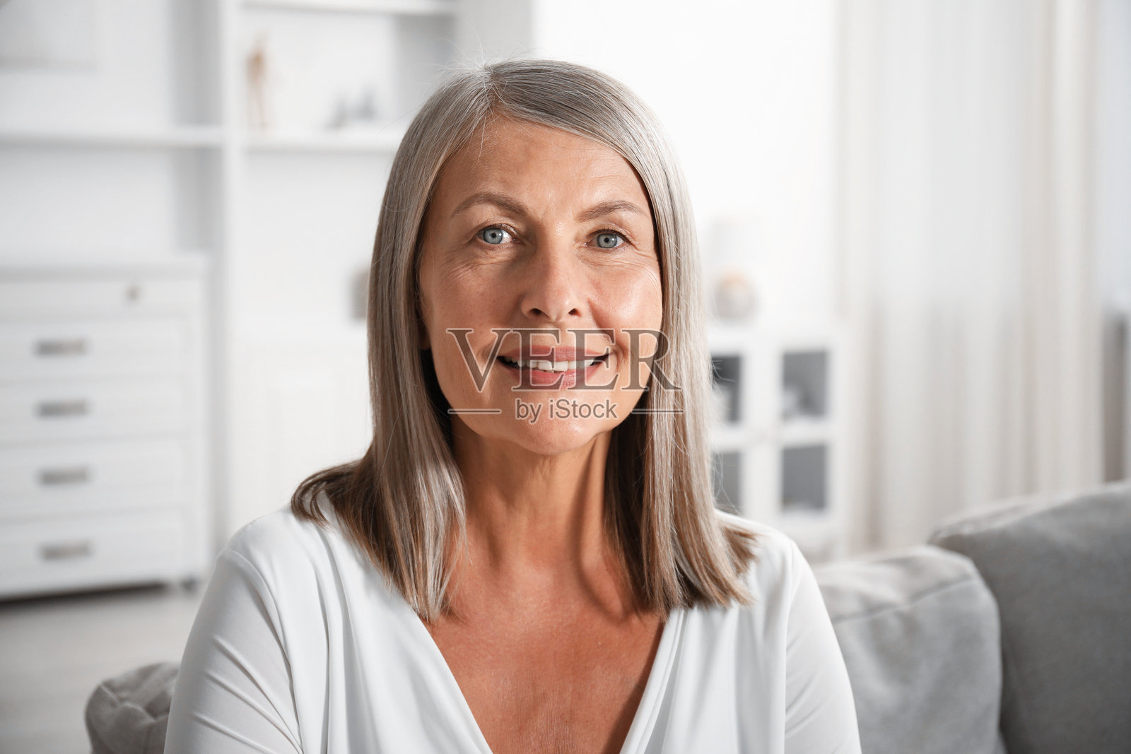 优雅的老年女性在家中的沙发上照片摄影图片