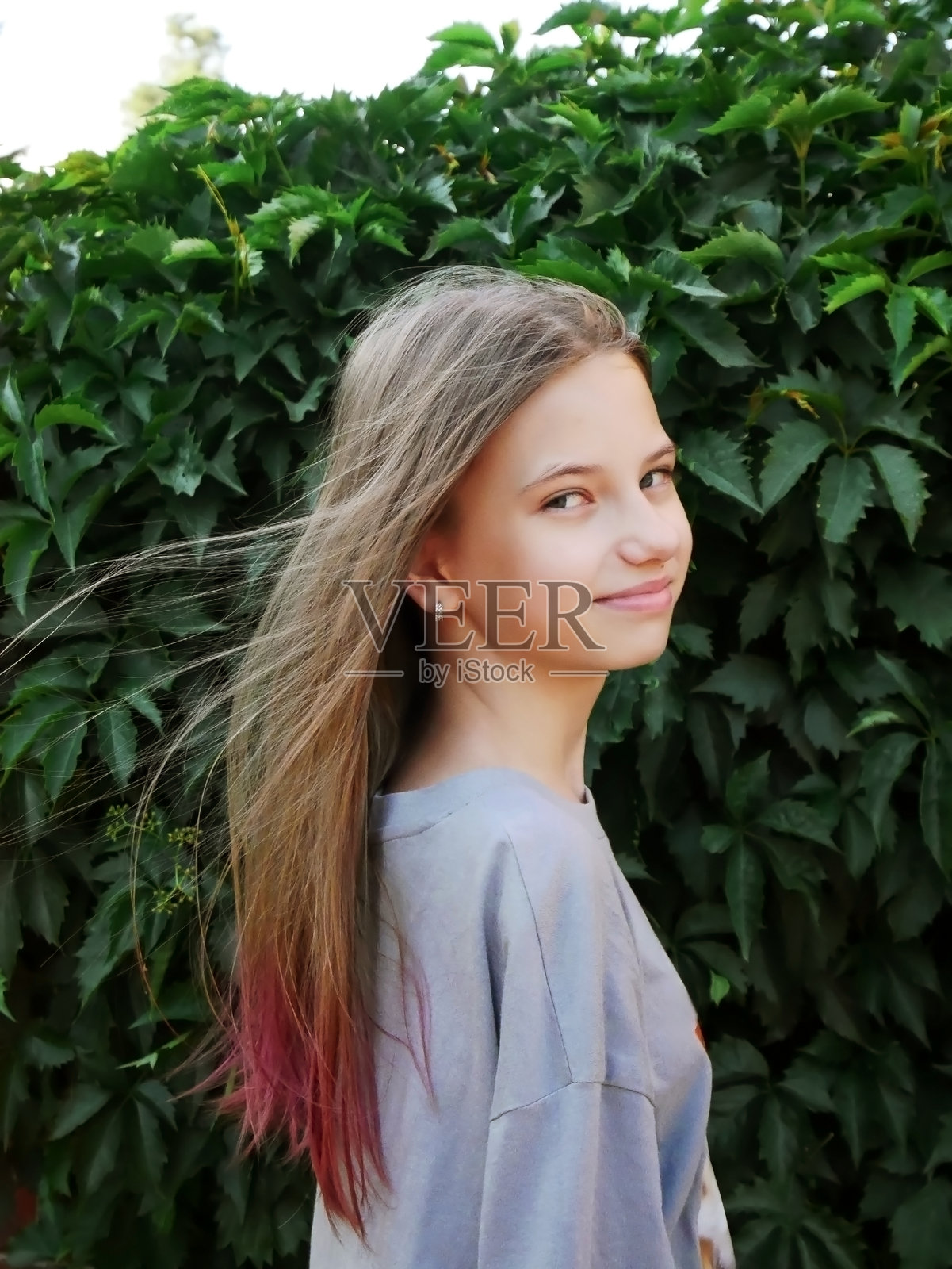 留着飘逸长发、佩戴彩色手链的女孩在户外照片摄影图片