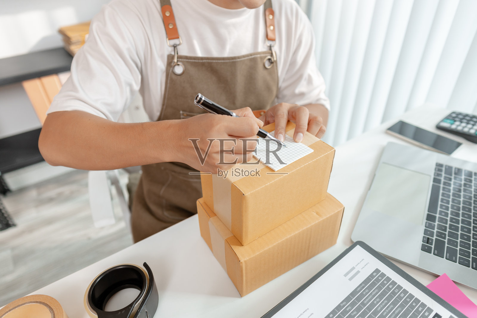 年轻企业家管理在线业务,准备包裹并处理电子商务运营,代表数字市场、初创企业增长和现代零售策略。照片摄影图片