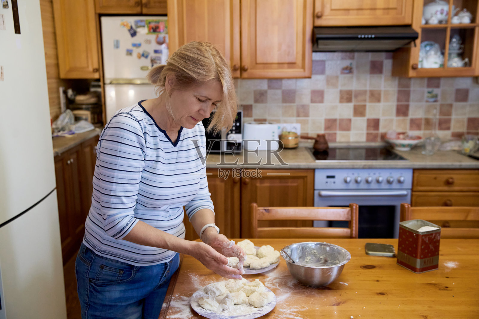 一位年长女性在家制作煎饼照片摄影图片