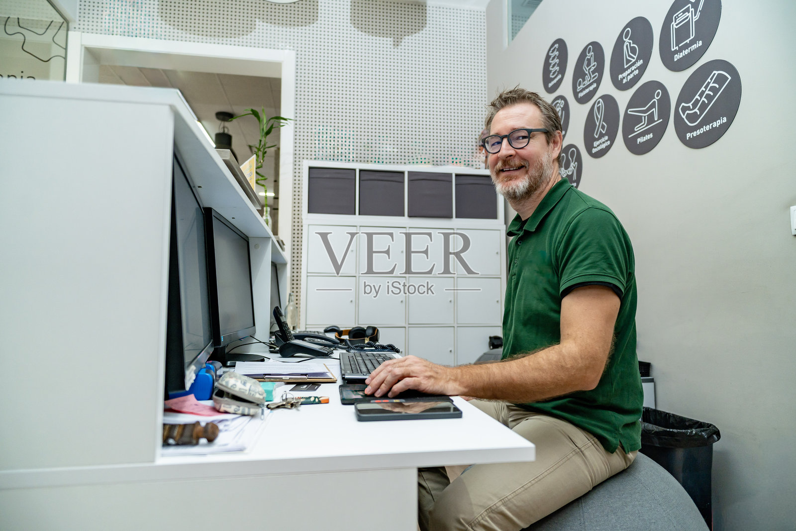 男物理治疗师在诊所的办公桌前工作照片摄影图片