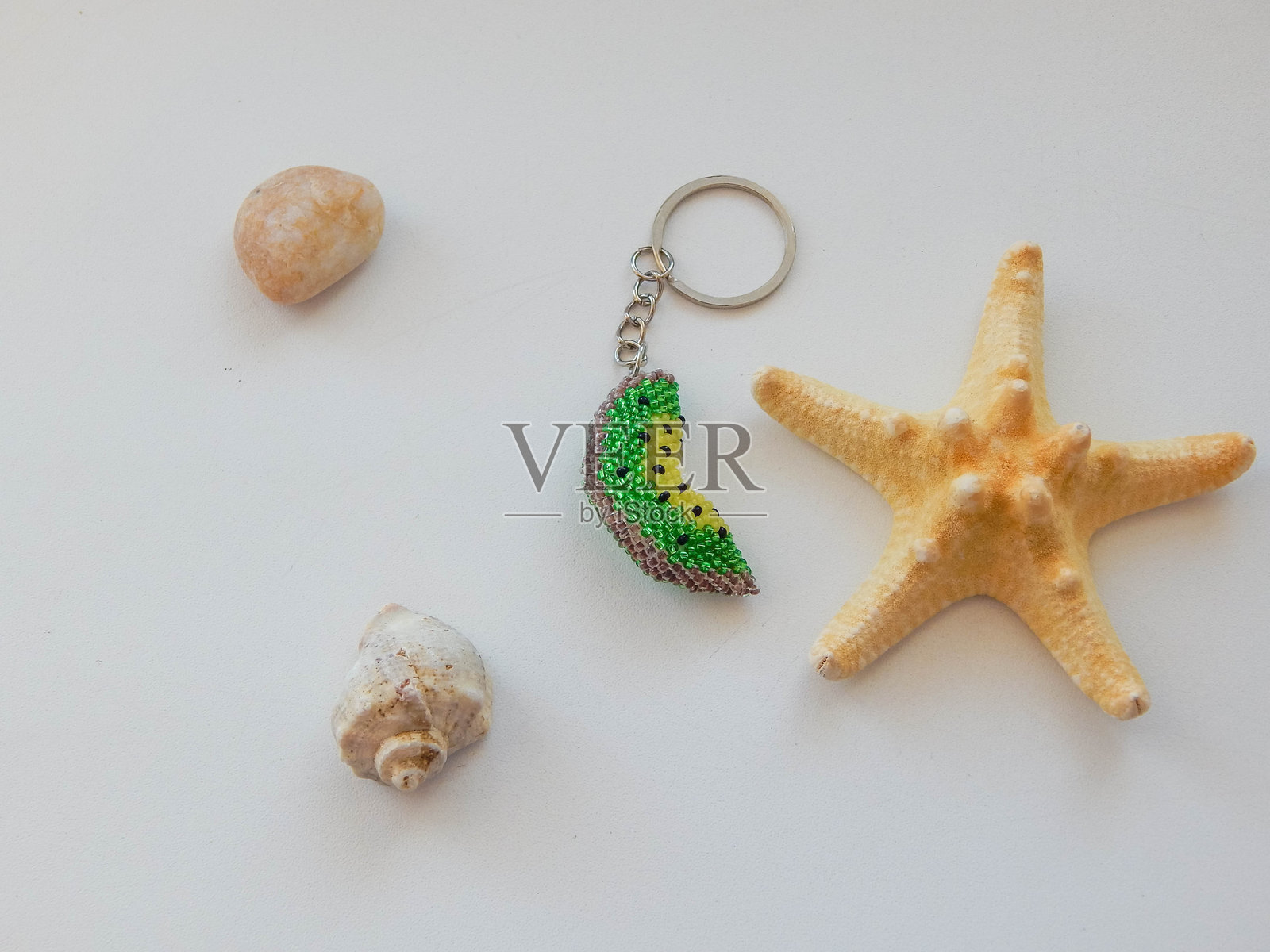 水果钥匙扣和海边卵石。色彩鲜艳的珠子钥匙扣和海滨照片摄影图片