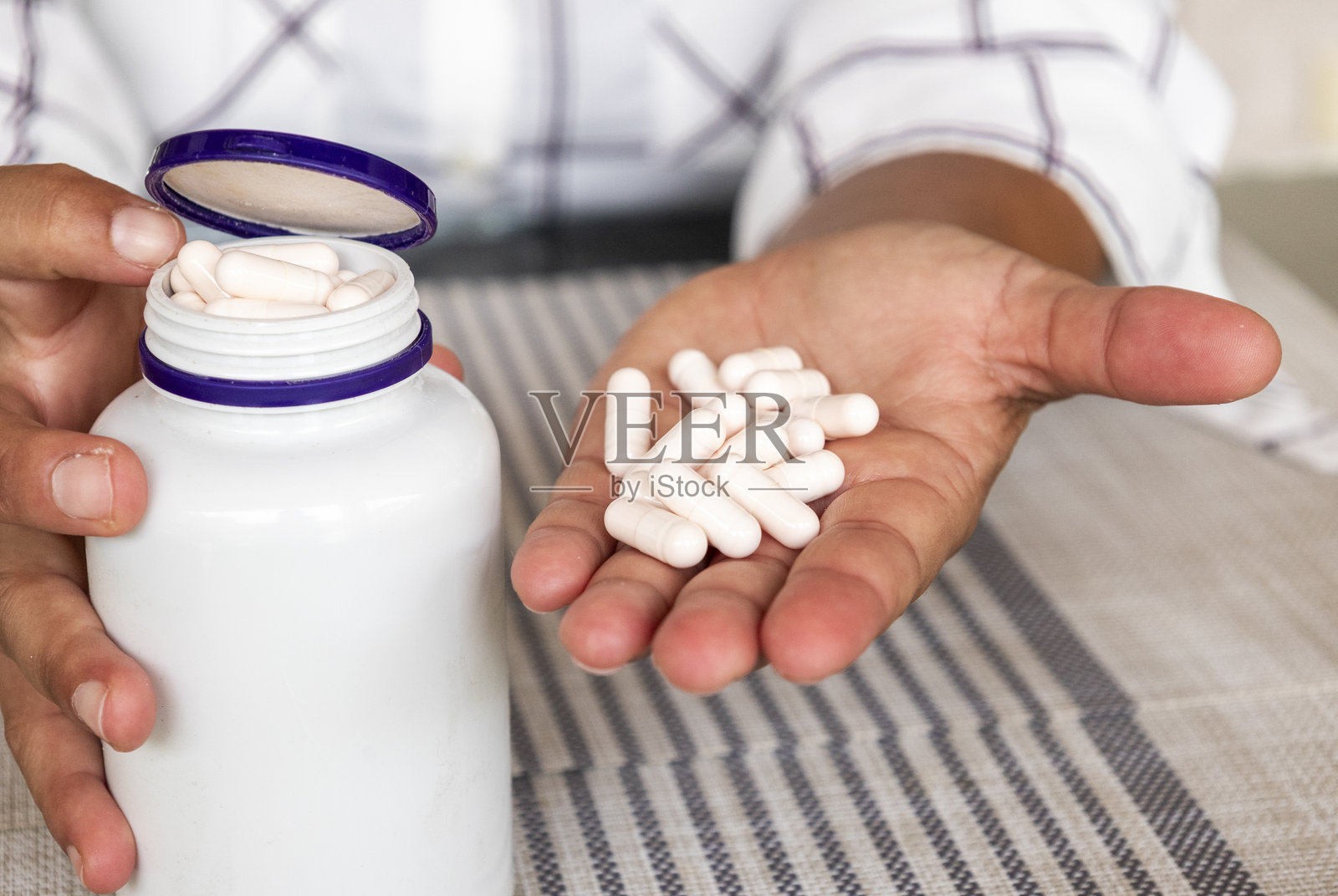 一个人拿着药丸和药瓶照片摄影图片