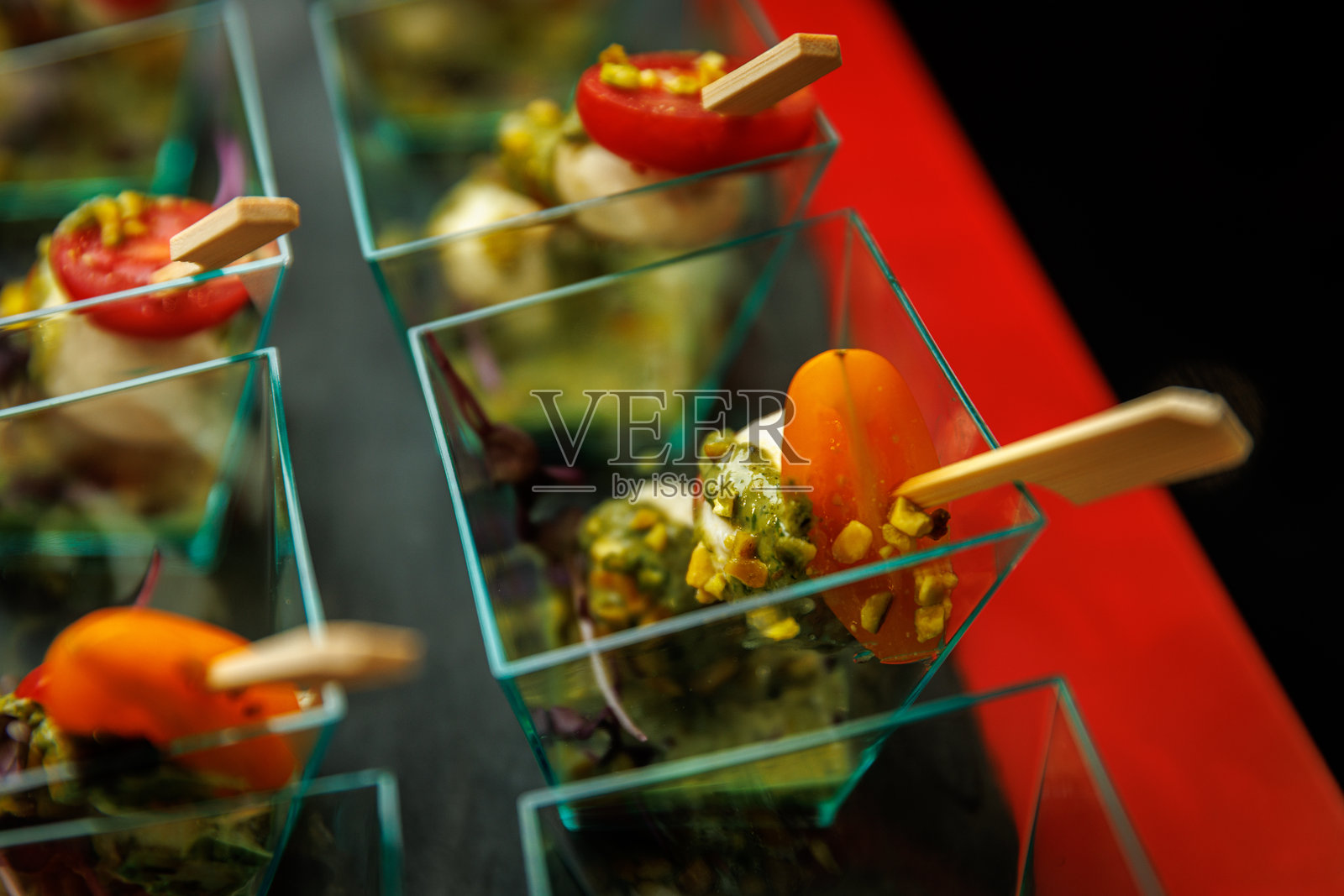 迷你卡普雷塞沙拉,配罗勒香蒜酱和番茄,盛装在塑料杯中照片摄影图片