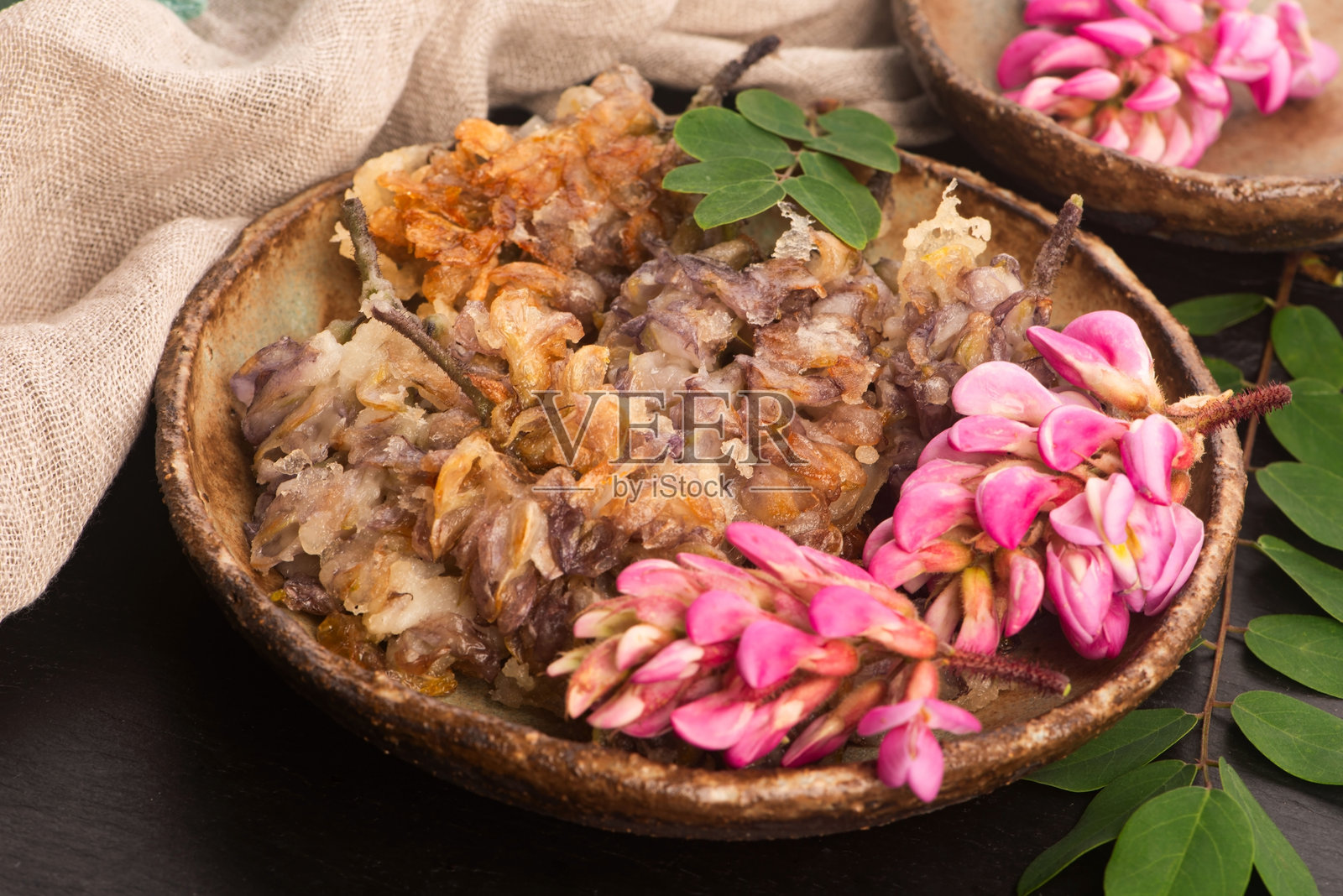 手工陶瓷盘上的粉色金合欢花天妇罗照片摄影图片