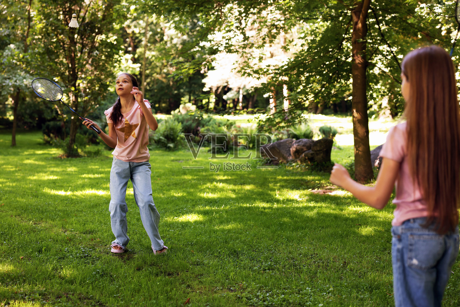 可爱的小女孩们在公园里玩羽毛球照片摄影图片
