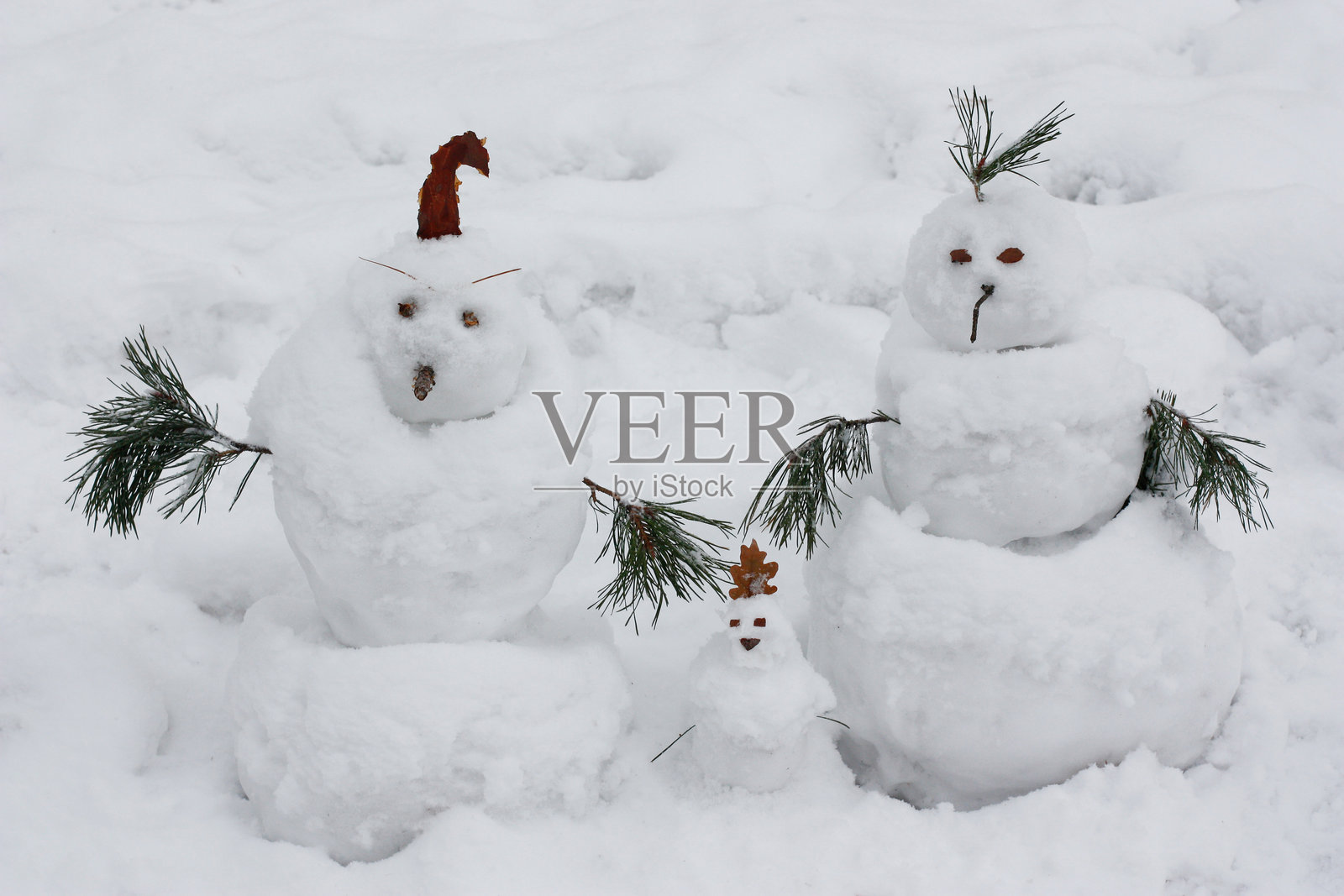 雪人一家在雪景背景下照片摄影图片