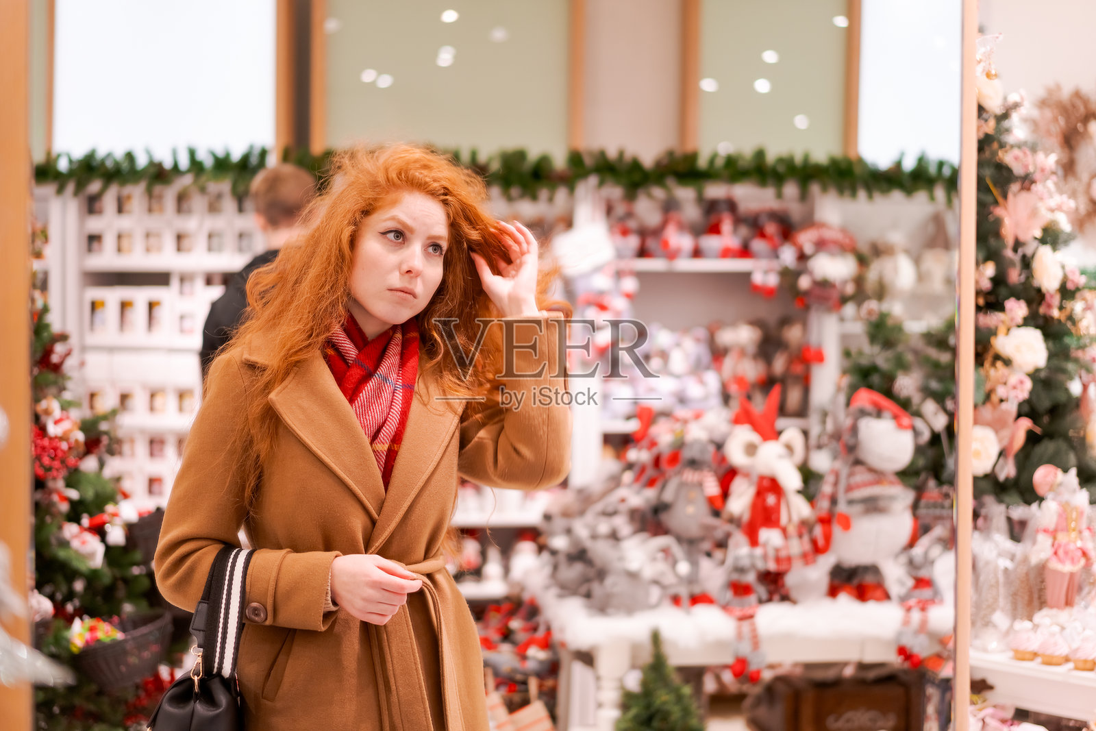 一位红发女子正在观看圣诞装饰品展示照片摄影图片
