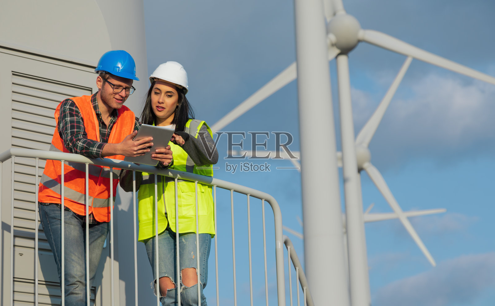 可再生能源工程师使用数字平板电脑协作进行风力涡轮机运营照片摄影图片