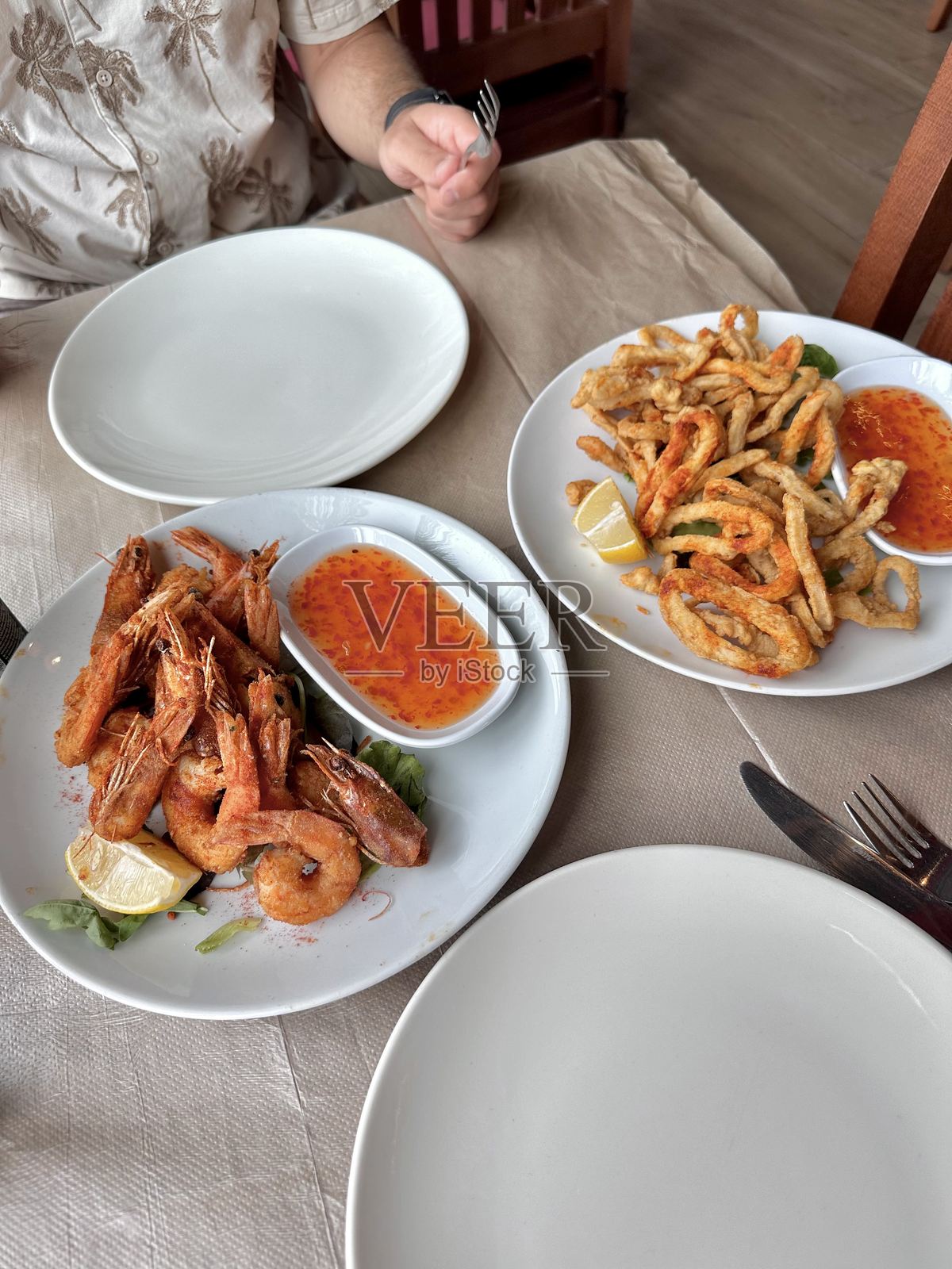 海鲜炸虾、鱿鱼圈配甜辣酱、香草,香脆金黄,调味辛辣鲜美,酥脆,餐厅,情侣用餐,午餐,餐桌摆设,餐具,叉子,刀,空盘,分享照片摄影图片