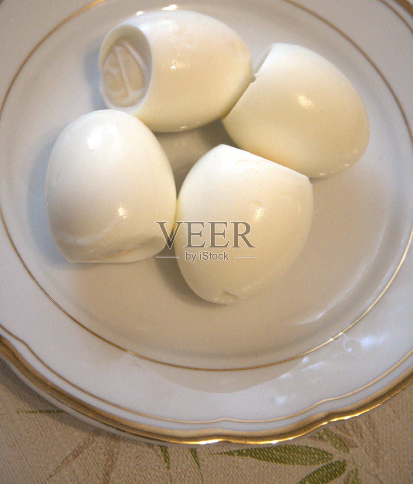 盘子里的4个去壳水煮蛋,特写照片摄影图片