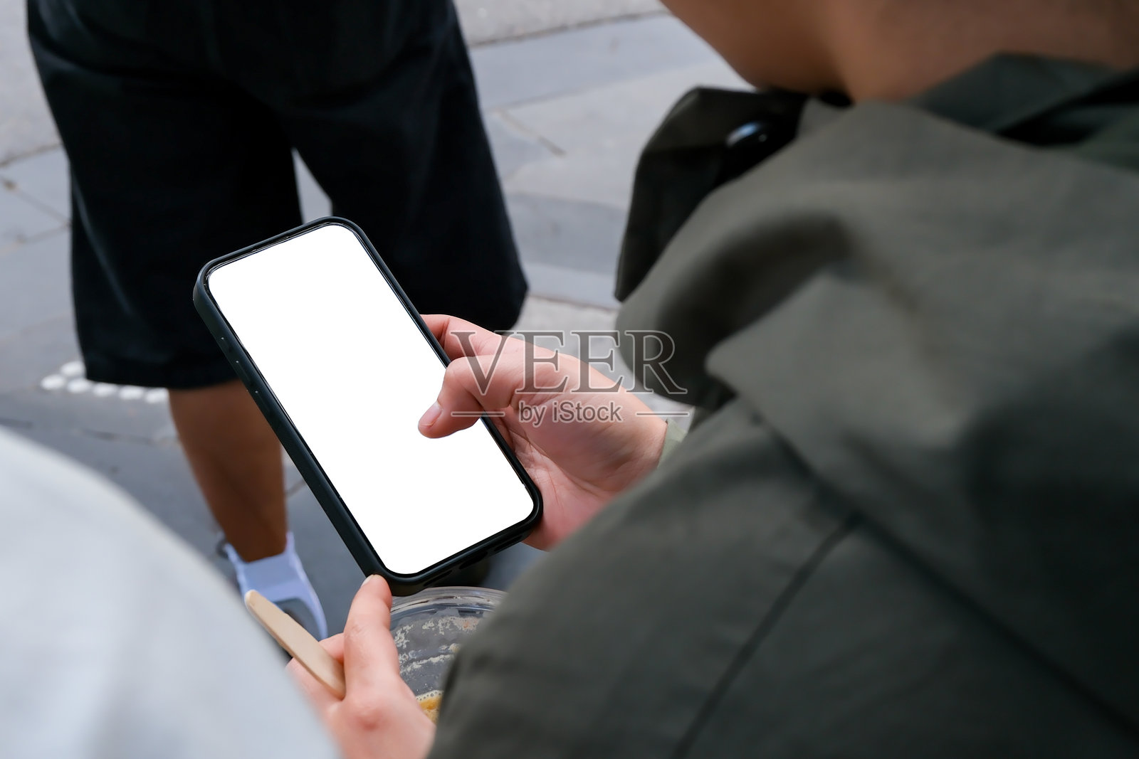 一位女士拿着一部带有空白白色屏幕的手机照片摄影图片