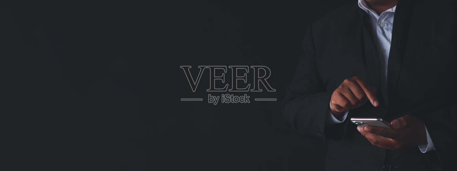 身着西装的商人在黑色背景上使用智能手机,带有复制空间作为横幅照片摄影图片