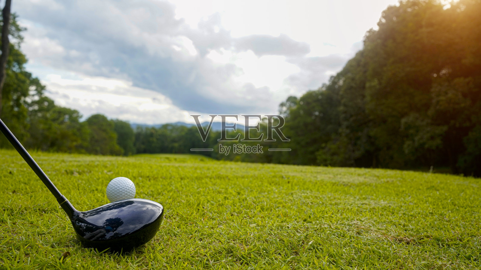 阳光明媚的清晨,在美丽的球场绿茵草坪上,高尔夫球杆和高尔夫球。照片摄影图片