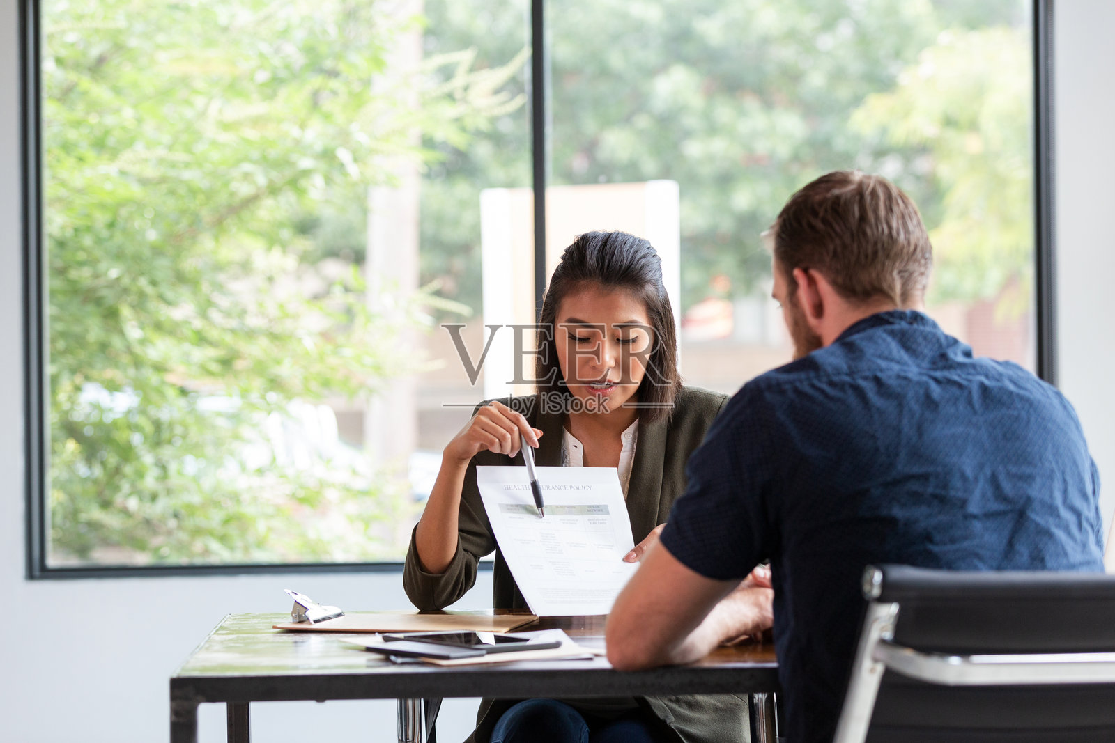 专业女性向男性客户解释医疗保险政策详情照片摄影图片