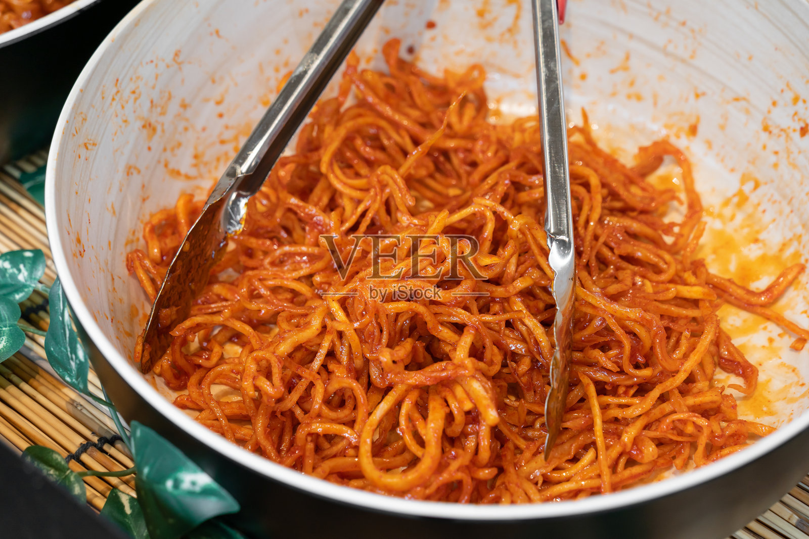 这道菜看起来是韩式鱿鱼干拌菜(Ojingeochae muchim),这是一道受欢迎的韩国小菜,由切成丝的干鱿鱼用甜辣酱调味制成。照片摄影图片