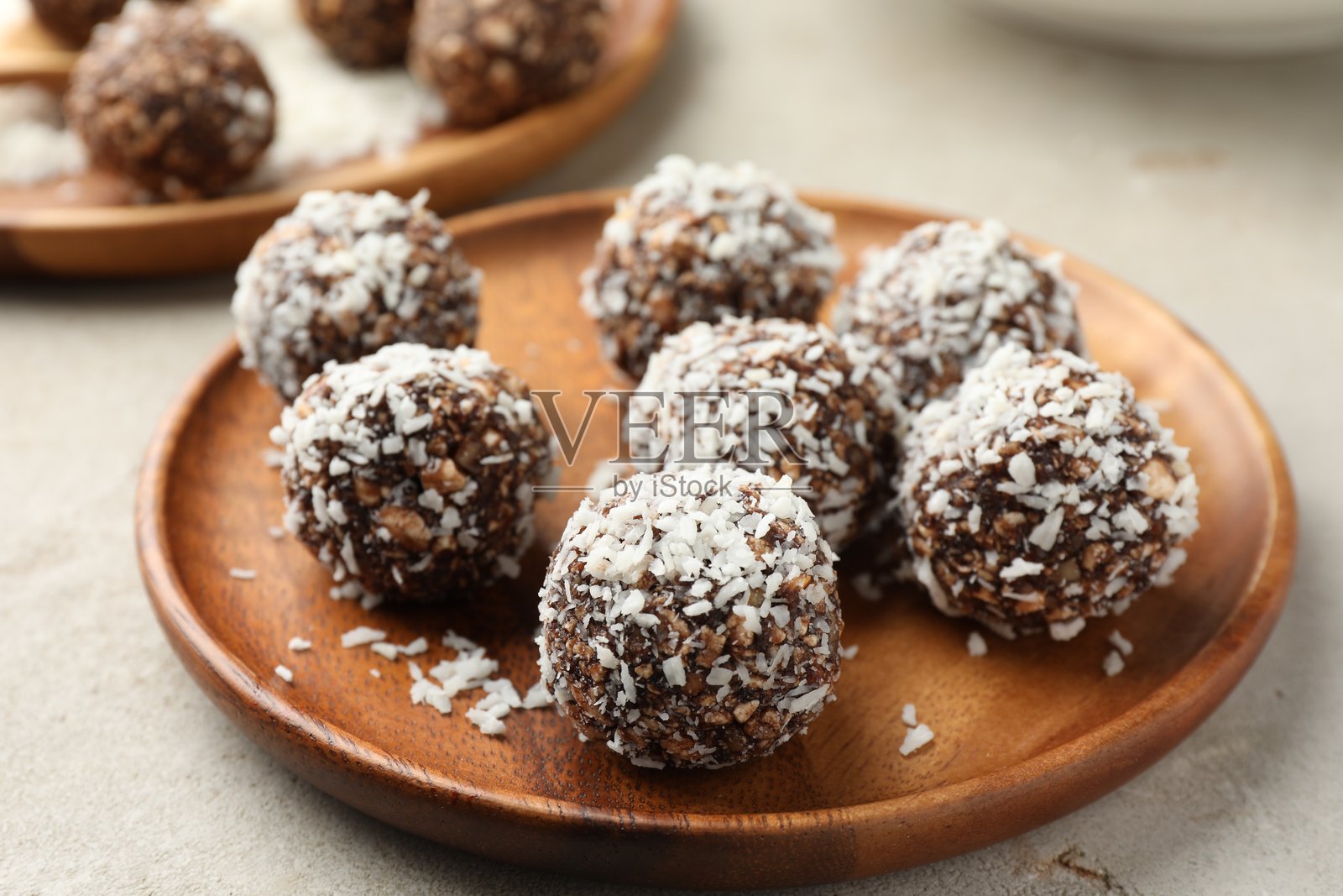 浅色桌面上美味的巧克力糖果,内含坚果和椰子片,特写照片摄影图片