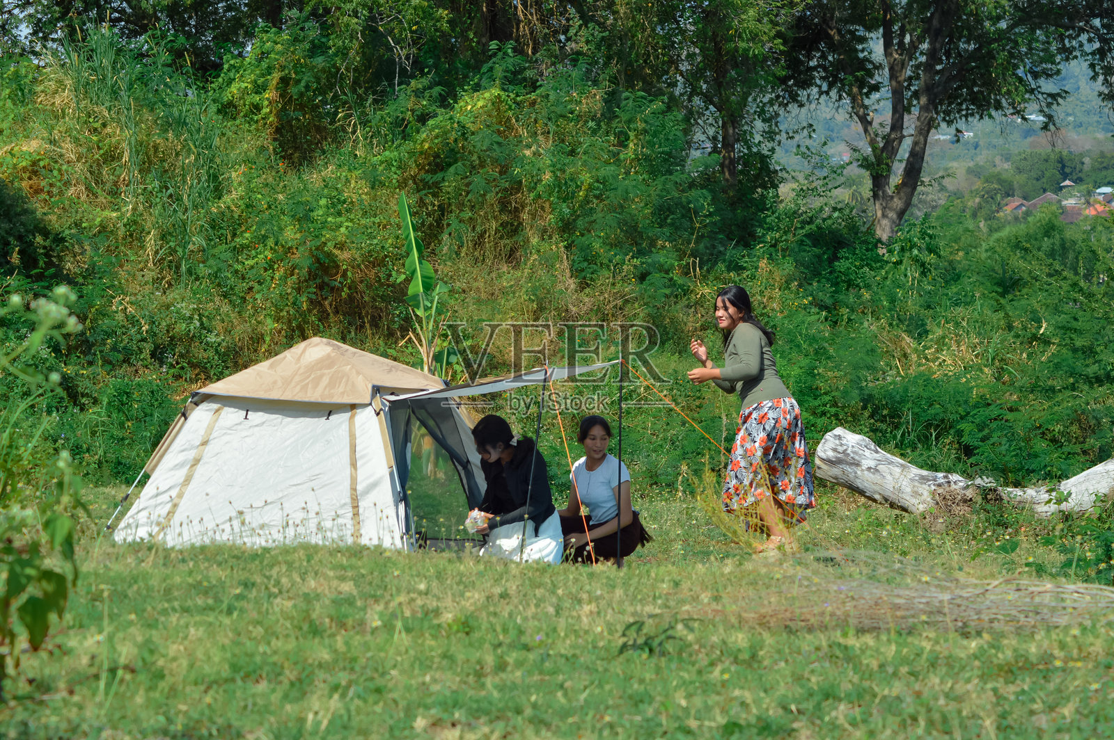 朋友们在营地帐篷附近的垫子上社交和放松照片摄影图片
