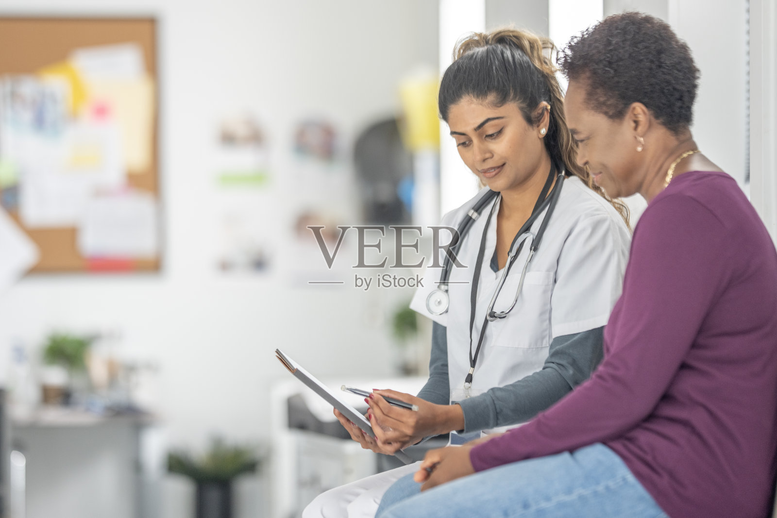 亚洲女医生在诊所里听诊并查看病人病历照片摄影图片