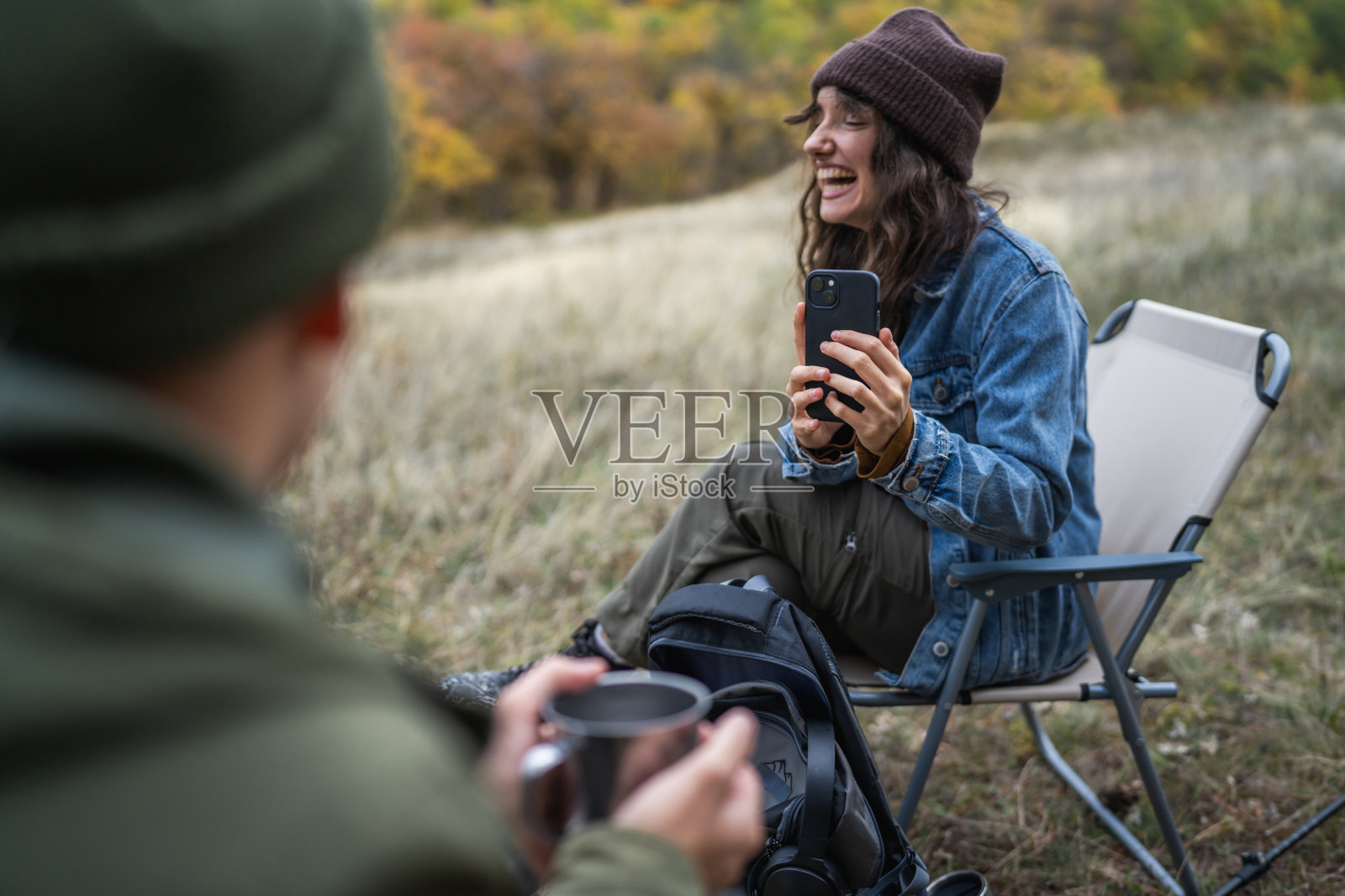一对情侣在森林里露营,用智能手机拍照照片摄影图片
