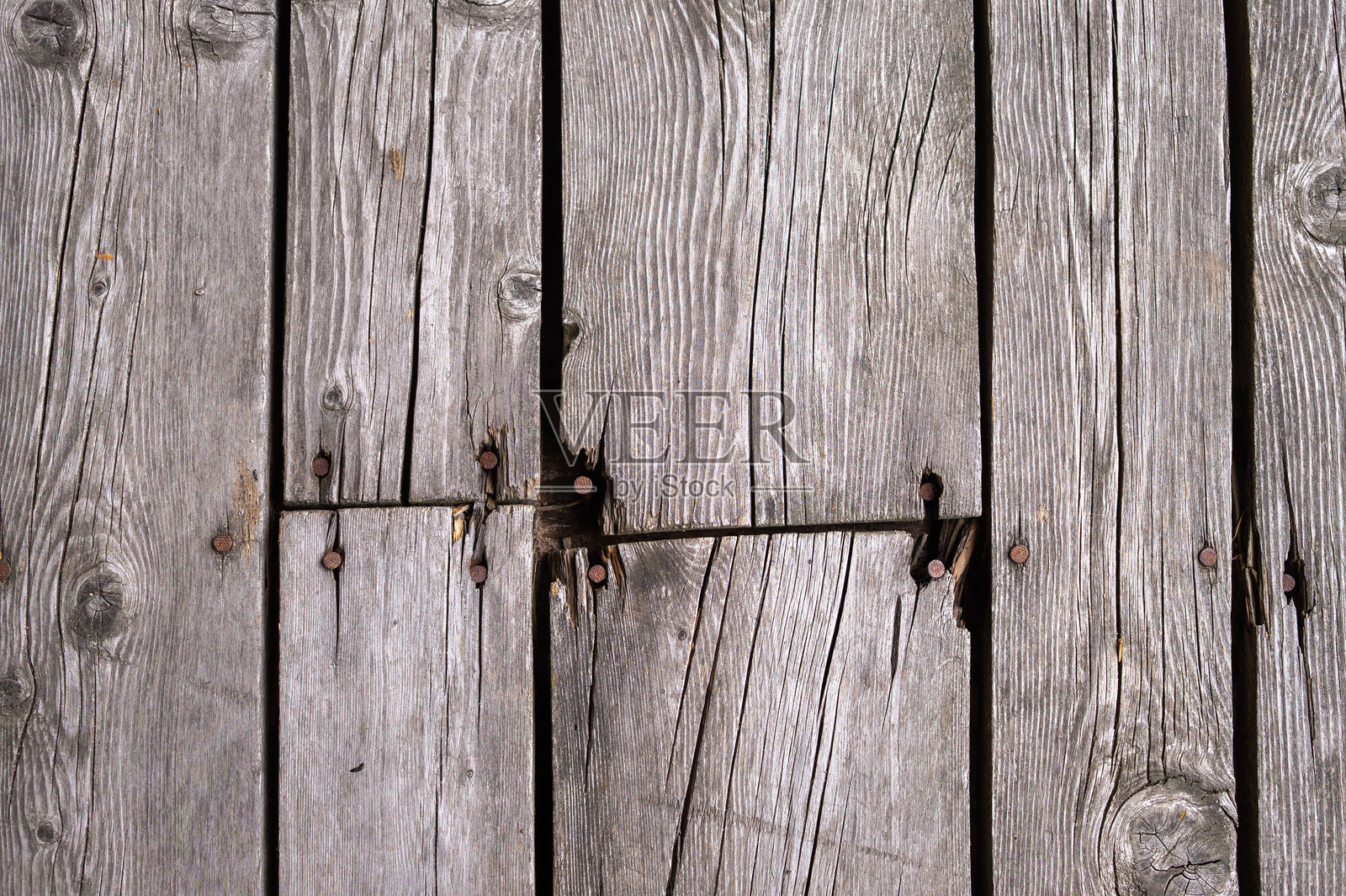 特写纹理户外表面,带有生锈的钉子和裂缝的饱经风霜的木甲板木板照片摄影图片