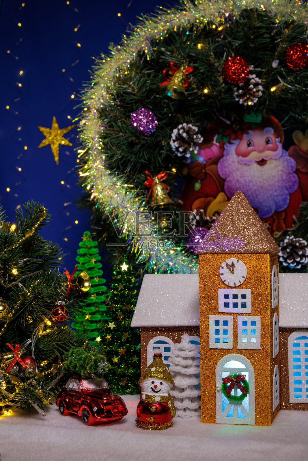 一座小教堂,旁边有一个雪人、一辆汽车,上方悬挂着一个降临节花环照片摄影图片