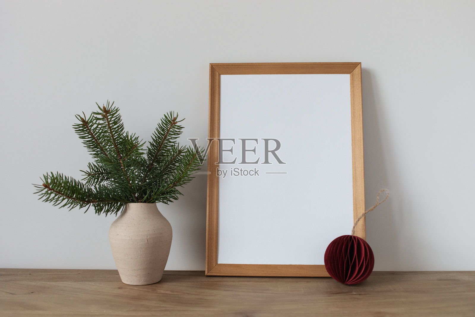 圣诞节和新年斯堪的纳维亚风格相框样机,带有松枝和节日装饰。白色的空白卡片放在空白墙上,用于冬季庆祝。照片摄影图片