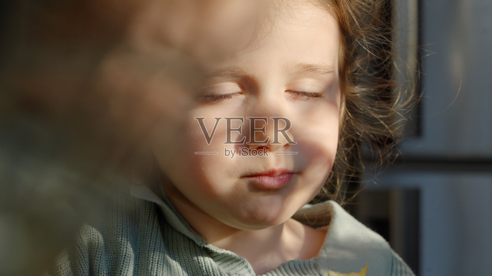 宁静。闭着眼睛的孩子沐浴在阳光下吃苹果的肖像照片摄影图片