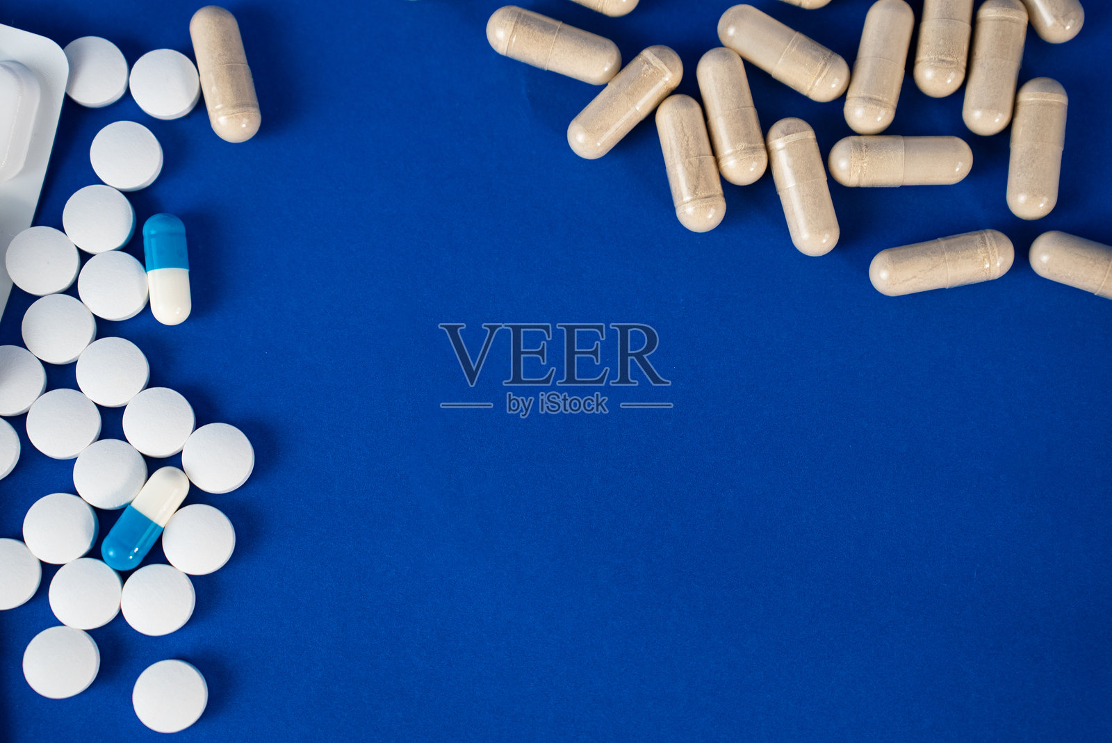 蓝色背景上的药丸和胶囊照片摄影图片