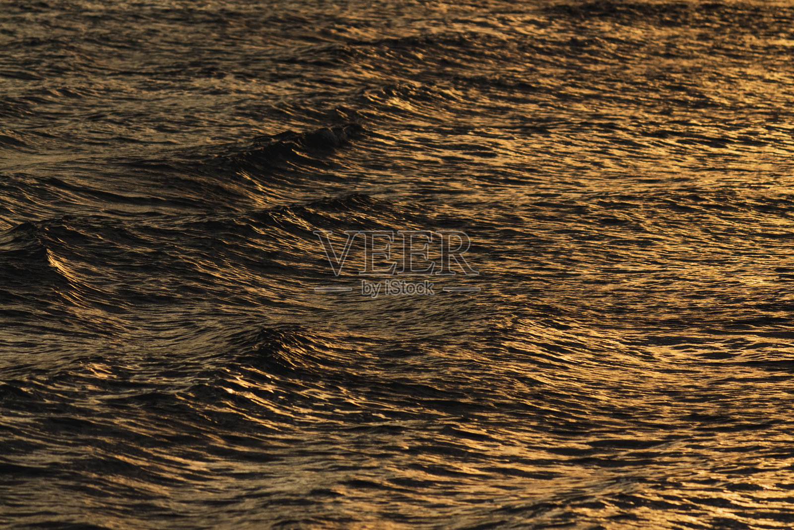 金色的波浪倒映着夕阳在平静海面上的美景照片摄影图片